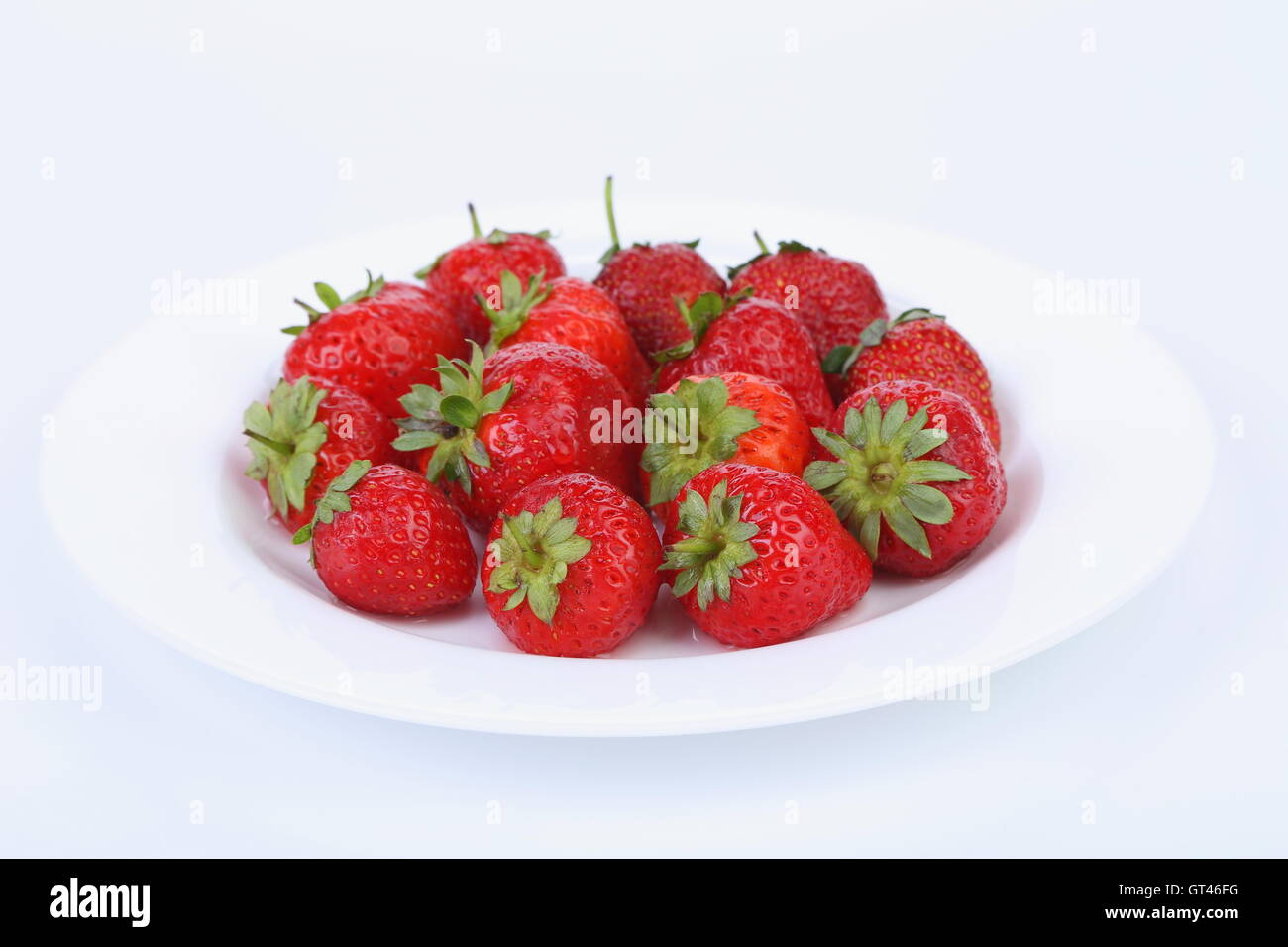 Les fraises mûres rouges frais sur une plaque blanche Banque D'Images