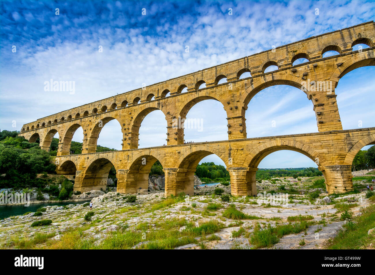 Pont du Gard, l'ancien aqueduc romain en Occitanie, France au milieu d'un ciel clair et d'un environnement luxuriant Banque D'Images