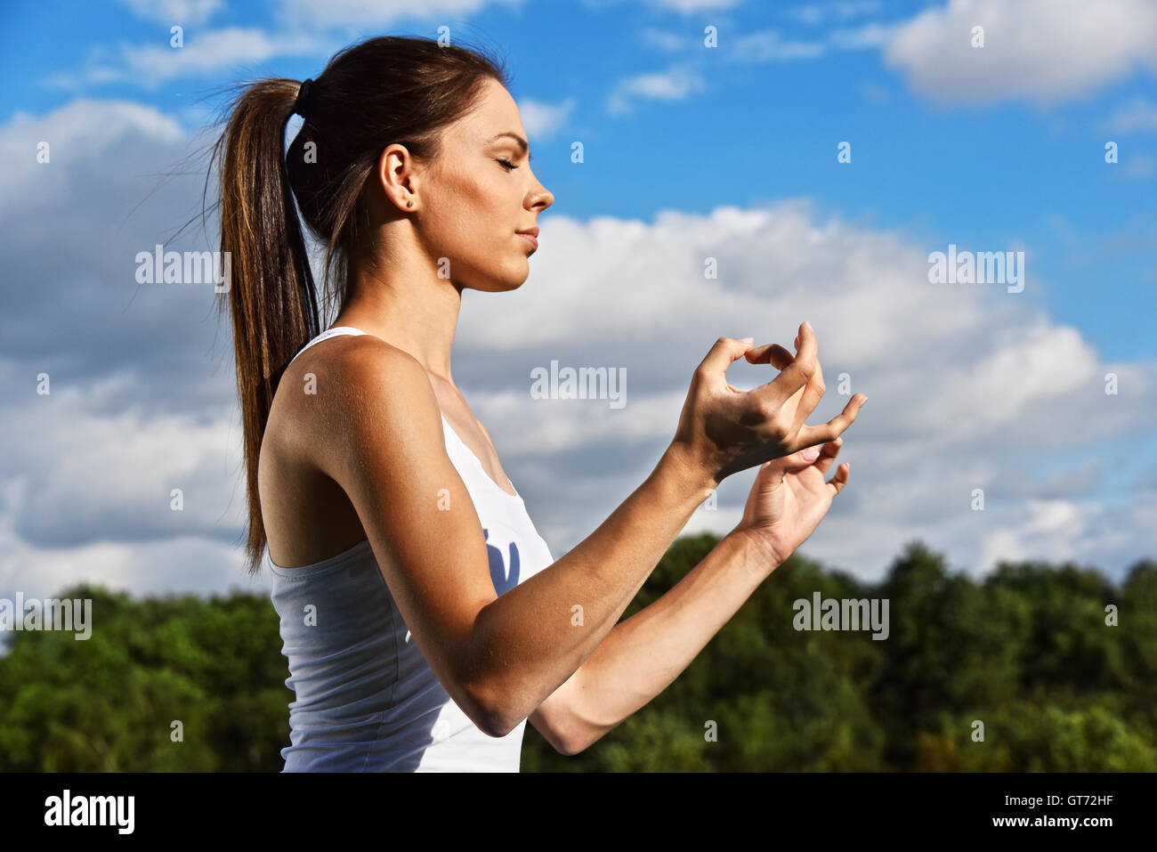 Jeune femme au cours de yoga méditation dans le parc. Banque D'Images