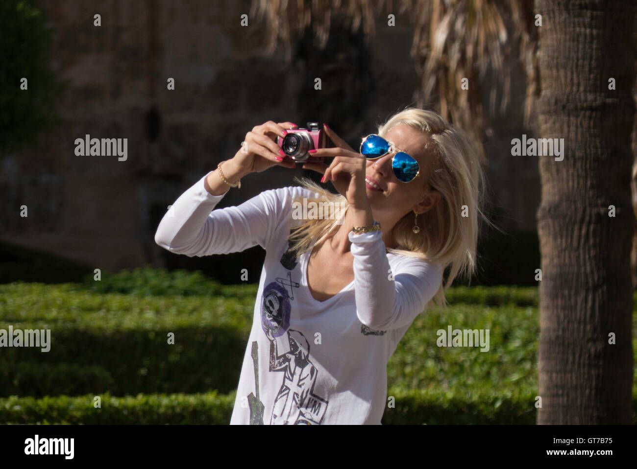 Femme blonde à prendre des photos avec un appareil photo numérique Banque D'Images