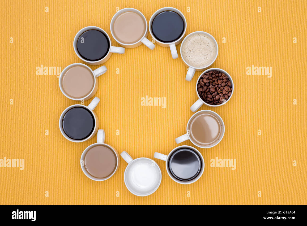 Tasses de café chaud dans différentes saveurs disposées en cercle sur un fond jaune, capturé en High Angle View. Banque D'Images