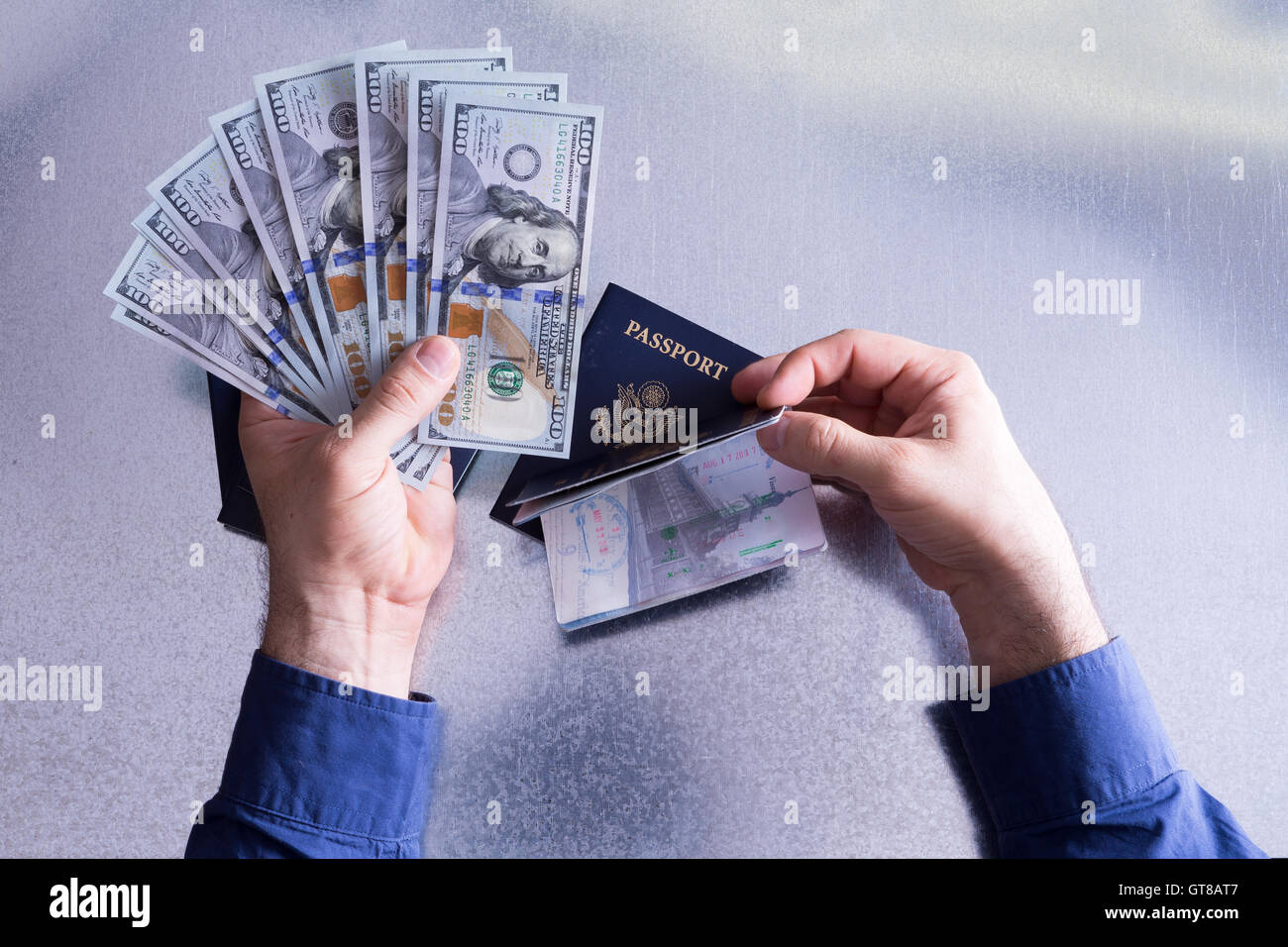Le droit de passeport Concept - Human Hand Holding Fan de 100 US Dollar factures papier et passeport de voyage au-dessus d'un tableau blanc. Banque D'Images