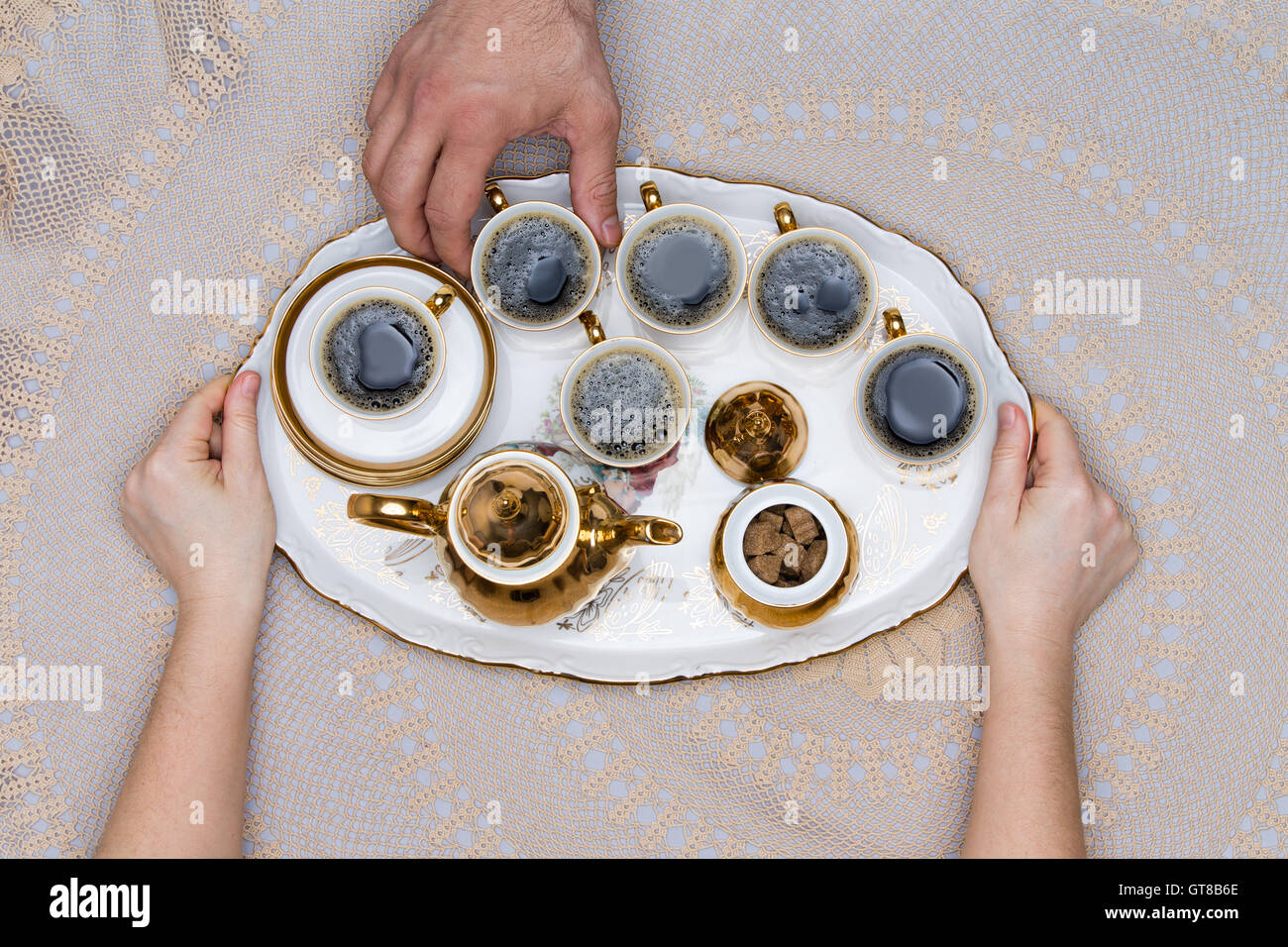 Six petites tasses de café turc sur un plateau, tenir à la main au-dessus d'un tableau blanc en High Angle View. Banque D'Images