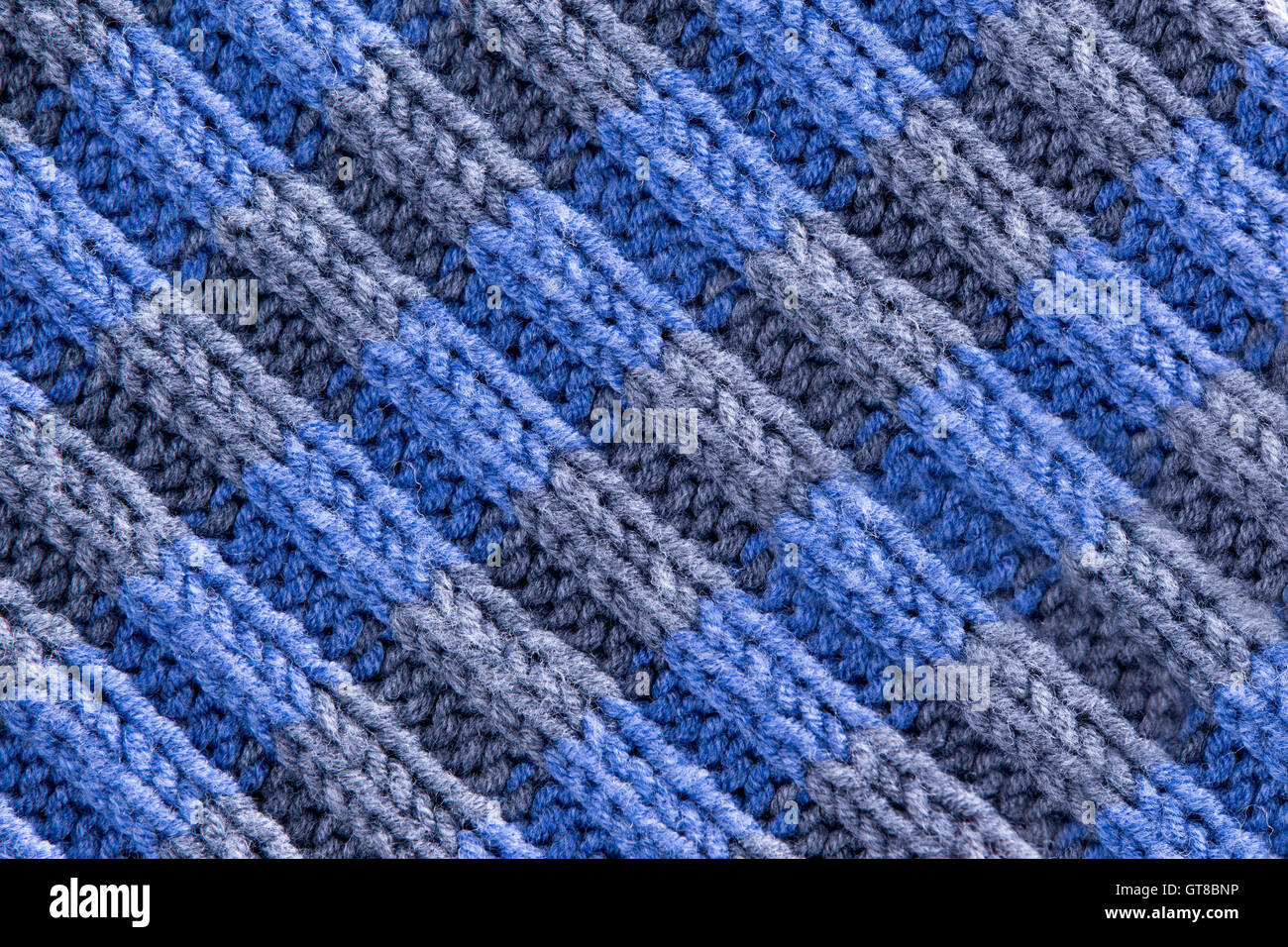 La texture de fond crochet fait à la main en bleu et gris avec une répétition de motif ondulé strié avec slalom, laine et fibre det Banque D'Images