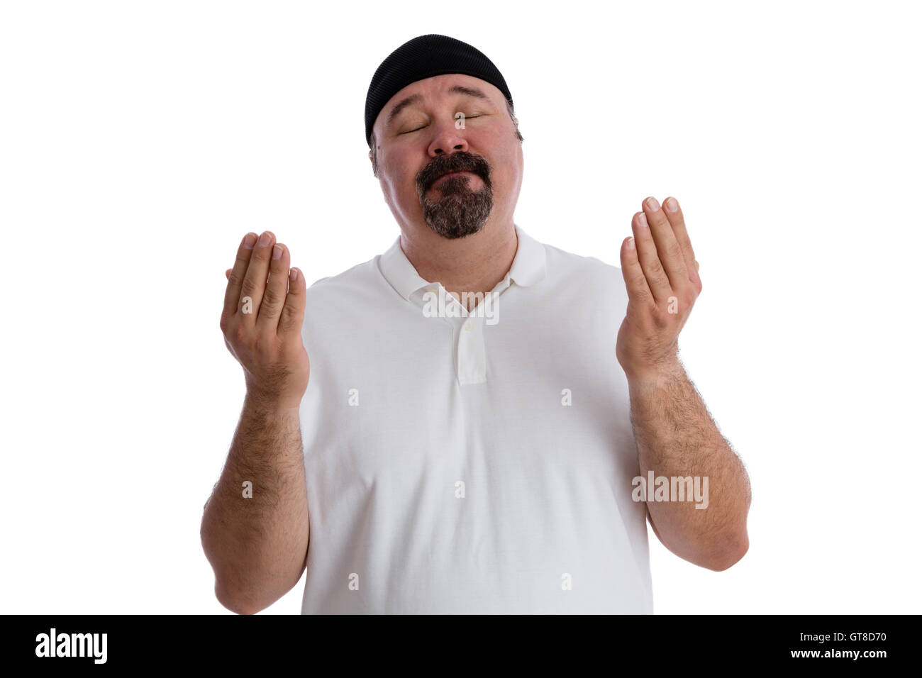 Religieux fervent homme d'âge moyen dans la prière profonde est debout avec les yeux fermés et les mains posées dans la supplication, isolated on white Banque D'Images