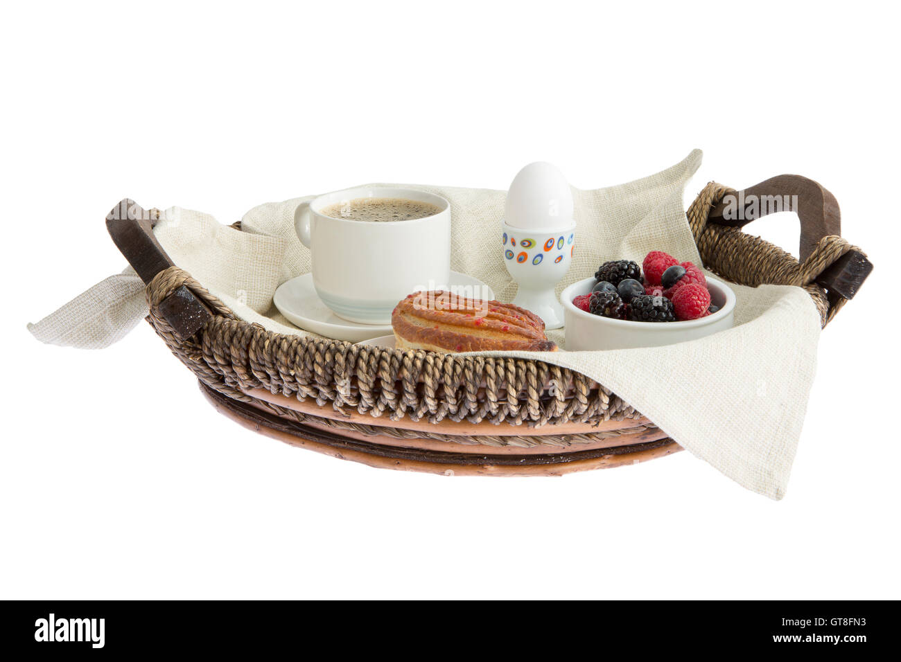 Vannerie rustique ensemble plateau de petit-déjeuner avec du café, des œufs, pâtisseries et fruits frais assortiment vue low angle isolated on white Banque D'Images