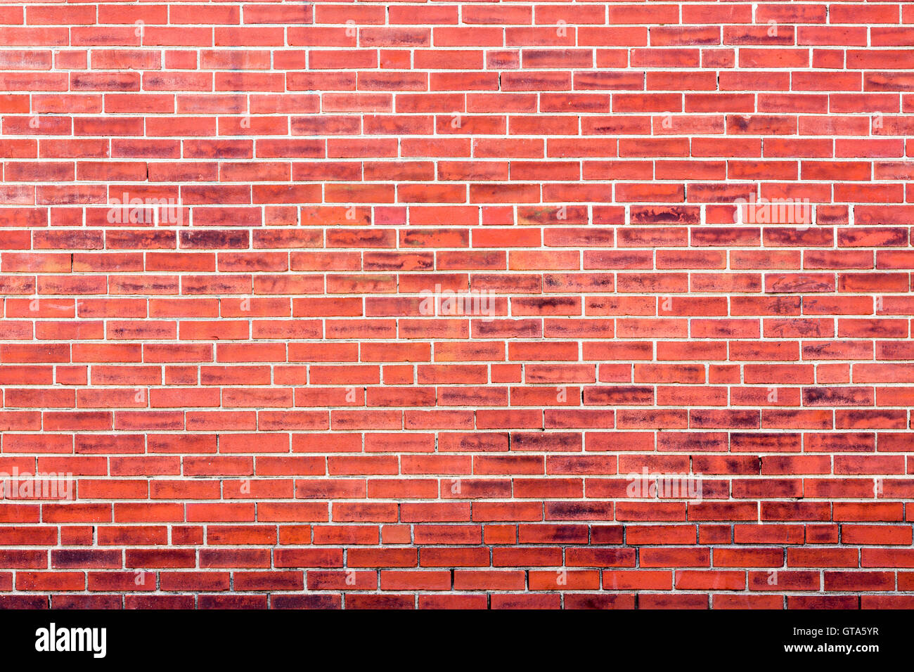Mur de brique rouge vif avec l'arrière-plan des tâches foncées et copie espace pour le concept à propos de inner city ou la vie urbaine Banque D'Images