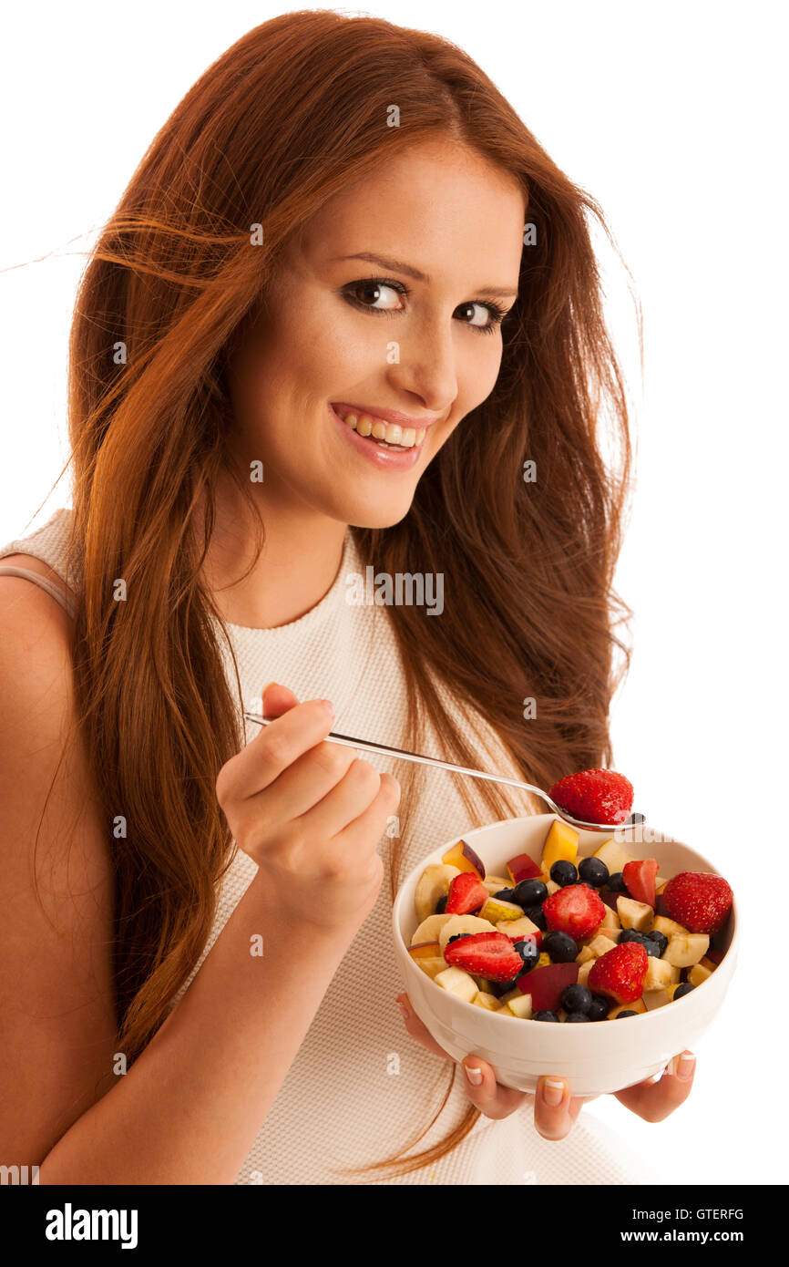 Une saine alimentation - femme mange un bol de salade de fruit isolated over white background - végétarien Banque D'Images