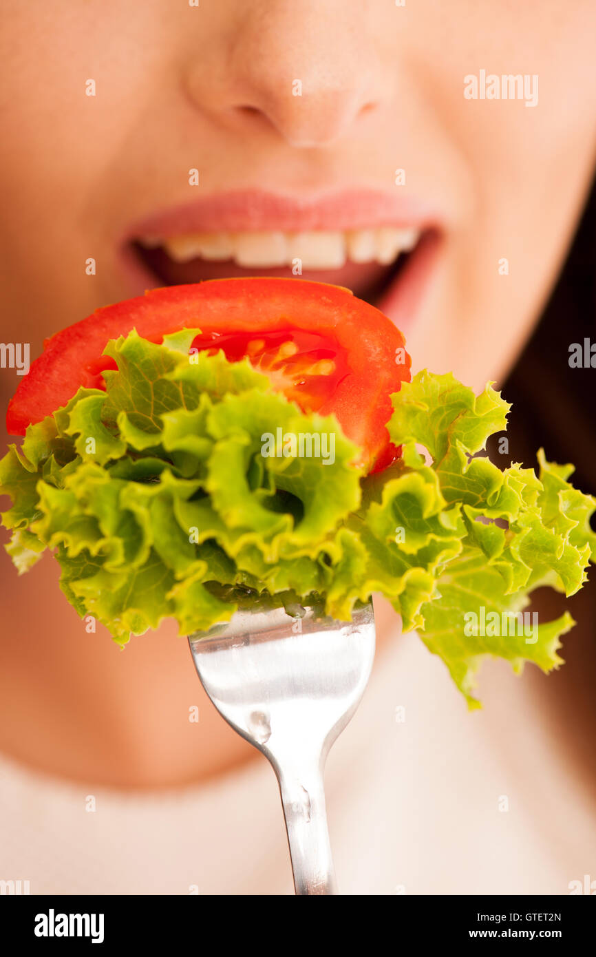 Une saine alimentation - femme mange un bol de salade grecque isolated over white background - végétarien Banque D'Images