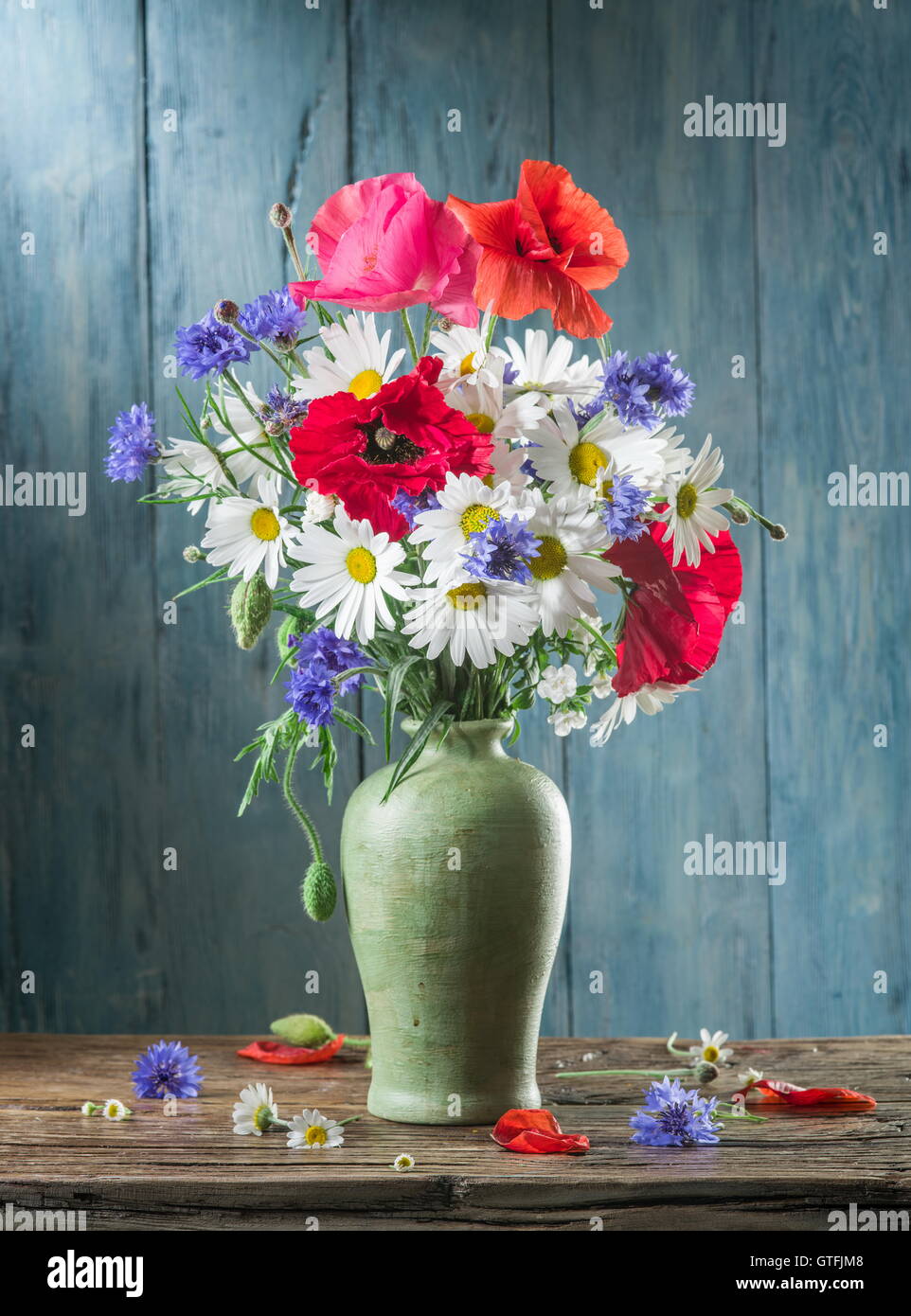 Bouquet de fleurs sur le terrain dans le vase sur la table en bois. Banque D'Images