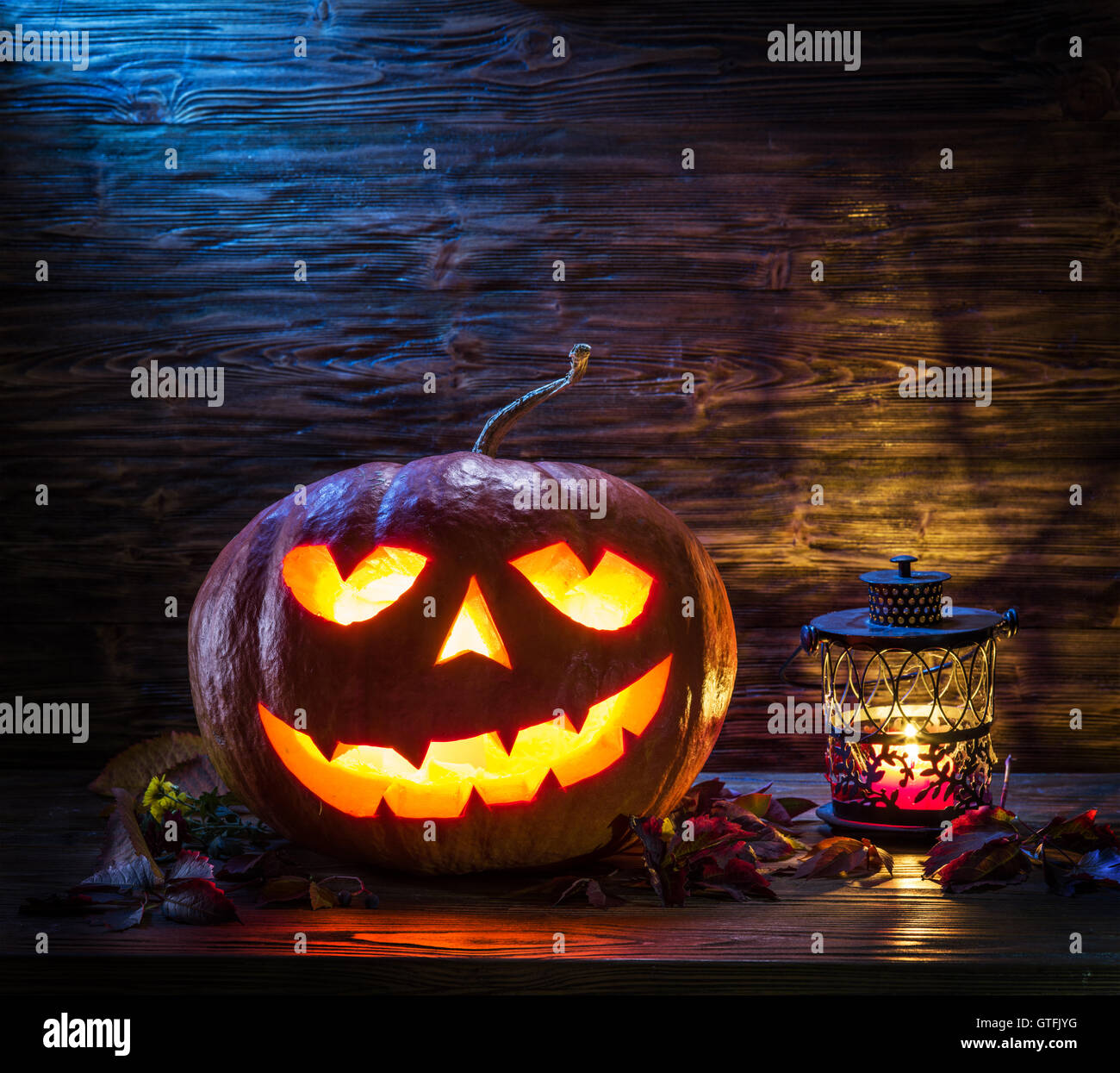 Lanterne citrouille souriant ou jack-o'-lantern est l'un des symboles de l'Halloween. Attribut d'Halloween. Fond de bois. Banque D'Images