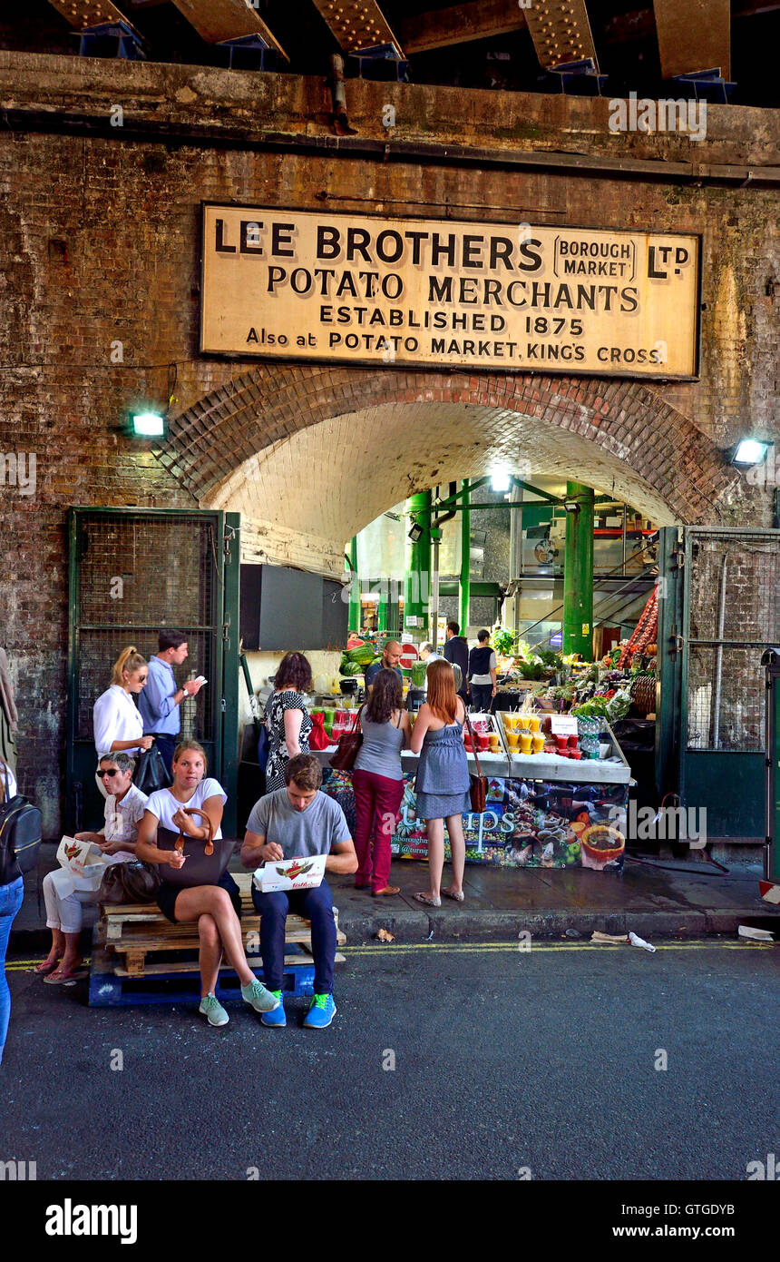 Londres, Angleterre, Royaume-Uni. Borough Market, Southwark. Les marchands de pommes de terre, les Frères Lee signe au-dessus de bloquer la vente de la nourriture et de la boisson. Banque D'Images
