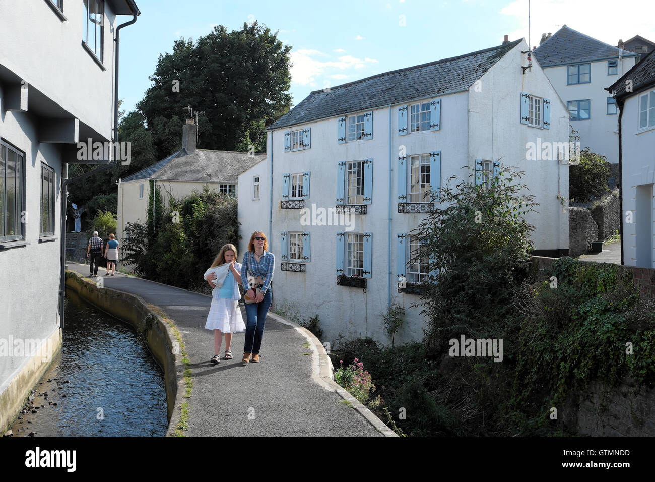 Les jeunes femmes marchant le long de la rivière Lym Mill Race qui s'écoule à travers la ville de Lyme Regis, dans le Dorset, Angleterre Royaume-uni KATHY DEWITT Banque D'Images