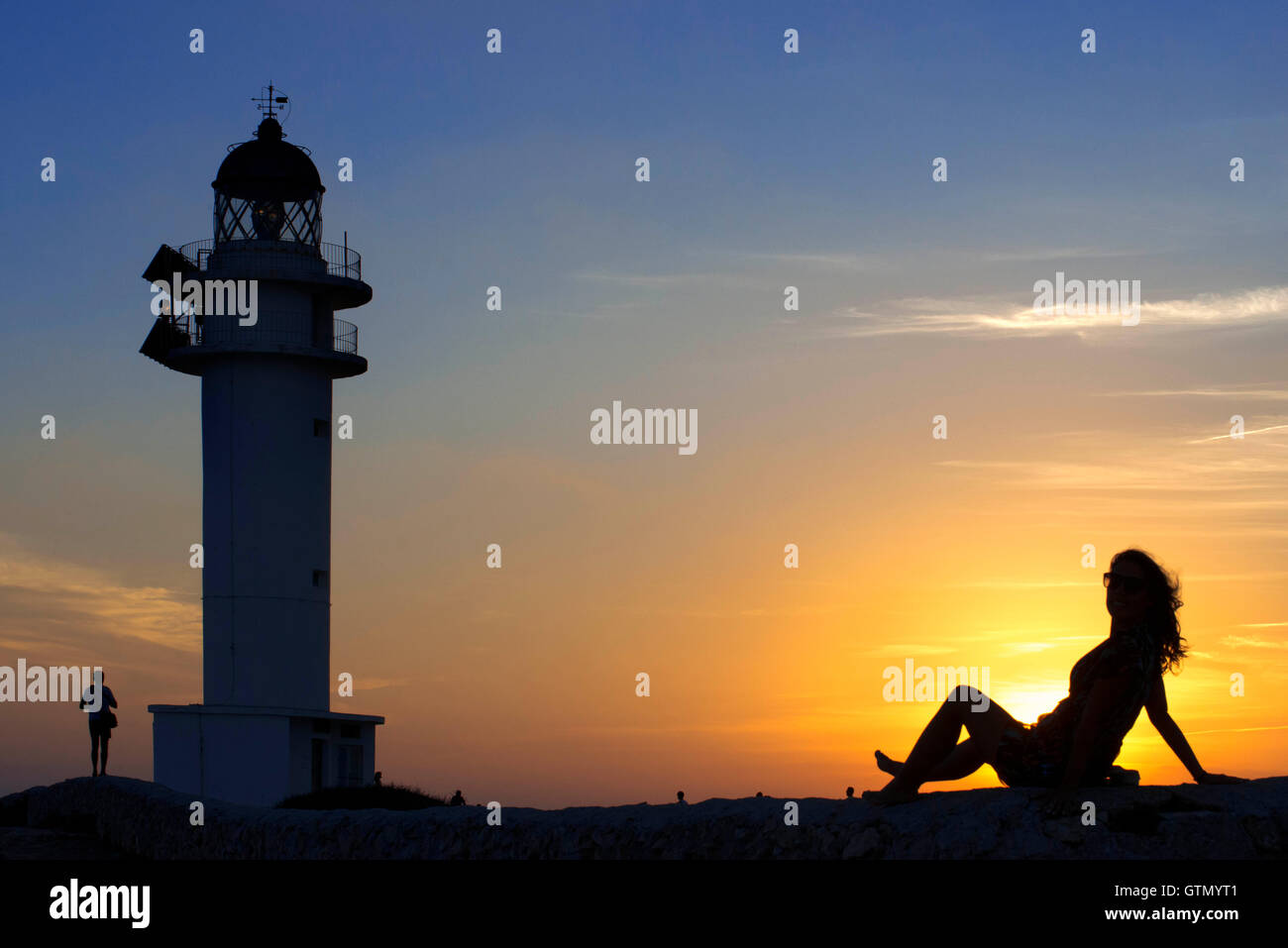 Le coucher du soleil. Jolie femme à contre-jour phare du Cap de Barbaria, à Minorque, Îles Balears. L'Espagne. Cap de Barbaria Formentera Banque D'Images