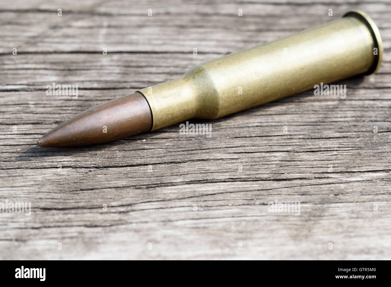 L'unfired Unique 7.62mm bullet et boîtier en laiton située sur une diagonale de surface en bois. Copie espace salon pour service militaire ou guntradi Banque D'Images