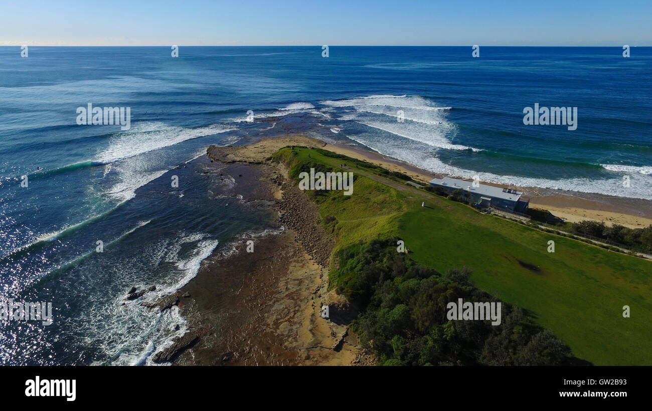Une vue aérienne de Sandon Point à Bulli, NSW, Australie. Le processus de réfraction des vagues est bien illustré comme ils l'enveloppent. Banque D'Images