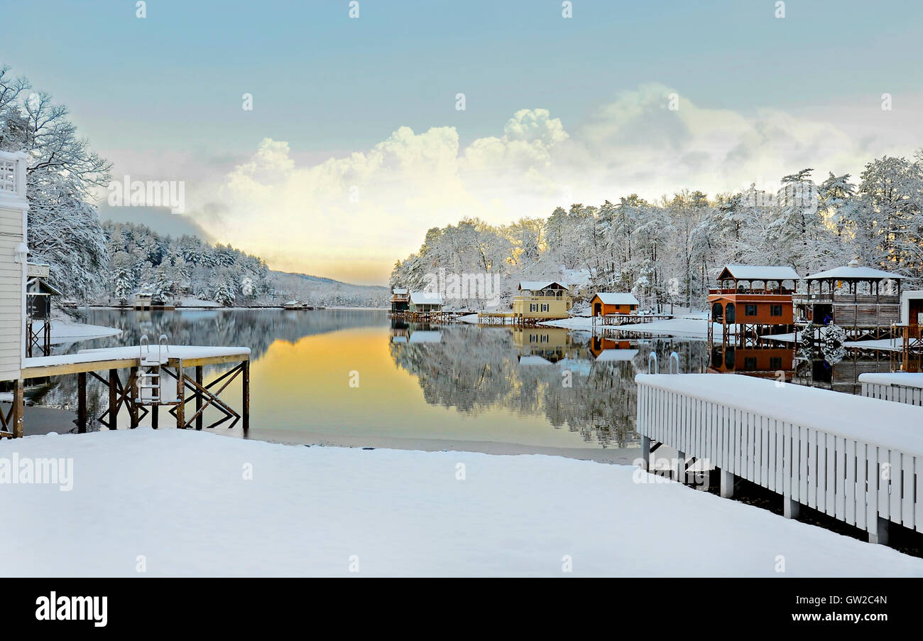Un beau matin d'hiver lake paysage avec maisons, neige, lac, montagne, et de réflexions. Banque D'Images