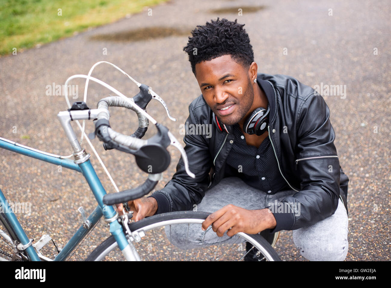 Jeune homme vérifie son vélo pneus. Banque D'Images