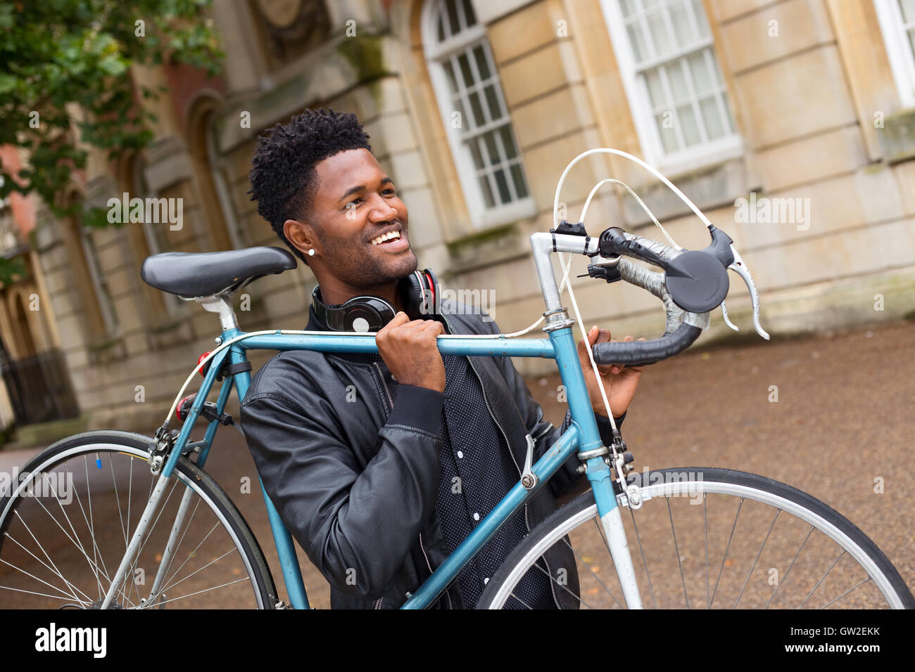 Jeune homme portant son vélo Banque D'Images