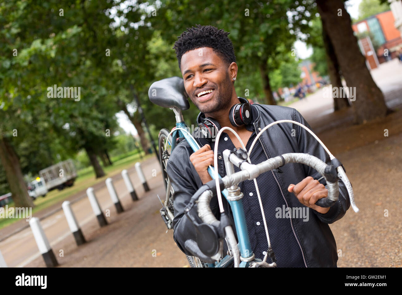 Jeune homme portant son vélo Banque D'Images