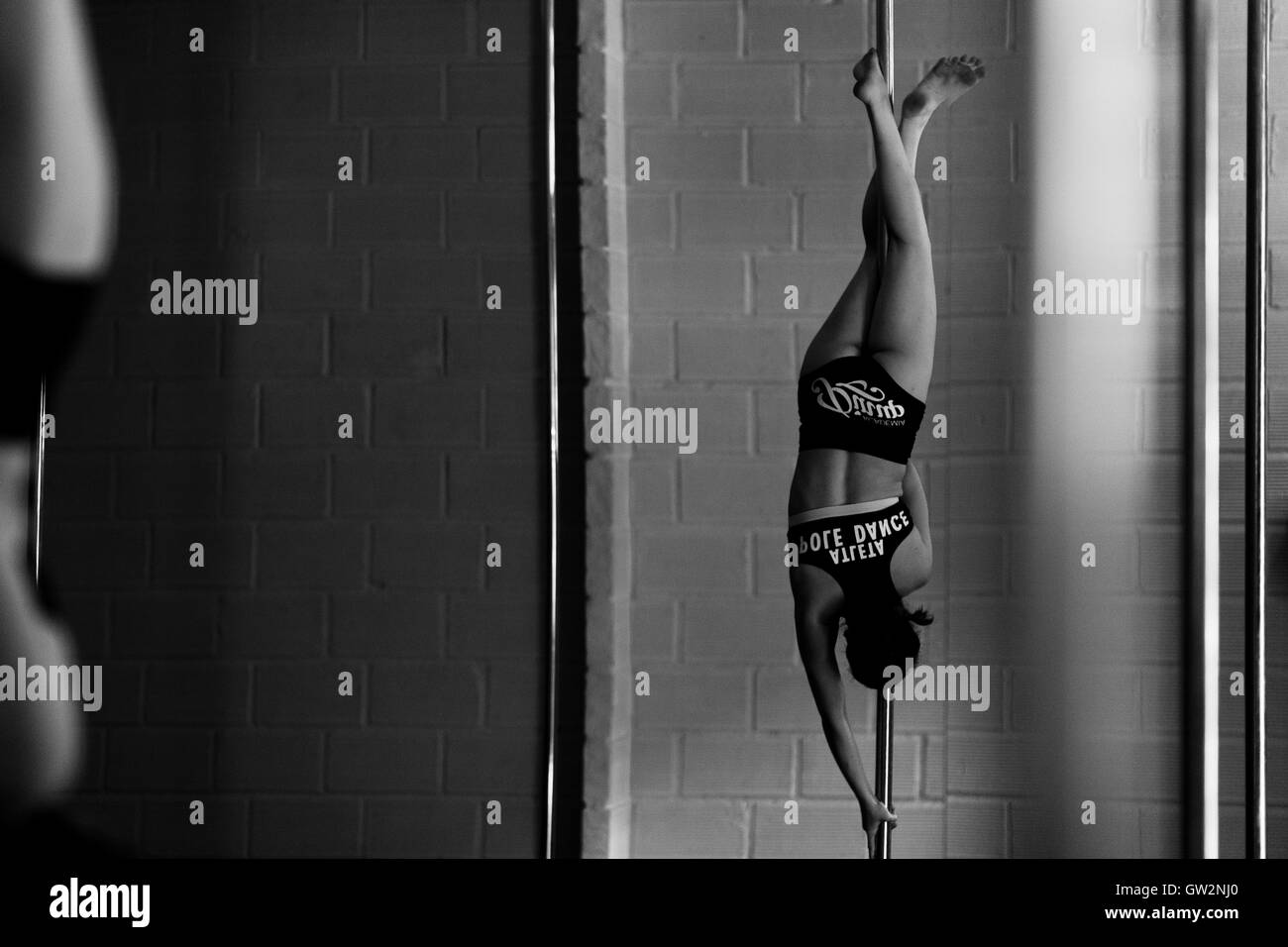 Aboultaif Valeria, une jeune danseuse, pôle colombien est suspendu la tête en bas à un mât lors d'une session de formation pole dance dans le monde universitaire Pin Up à Medellín, Colombie. Banque D'Images