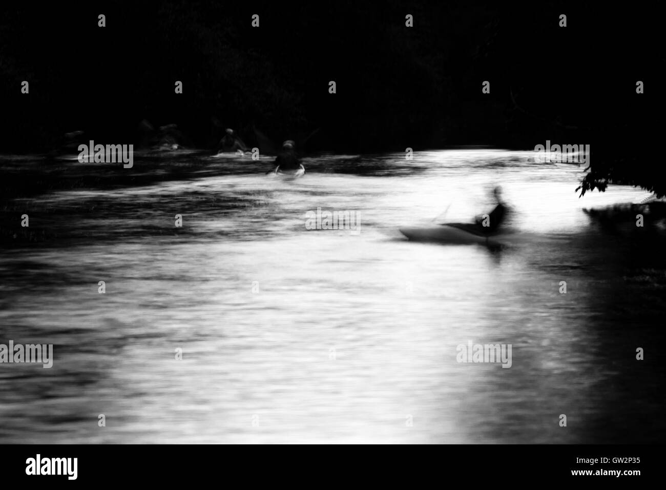 Les canoéistes sur la rivière Avon par clair de lune. Une longue exposition de personnes du kayak sur la rivière la nuit, en noir et blanc Banque D'Images