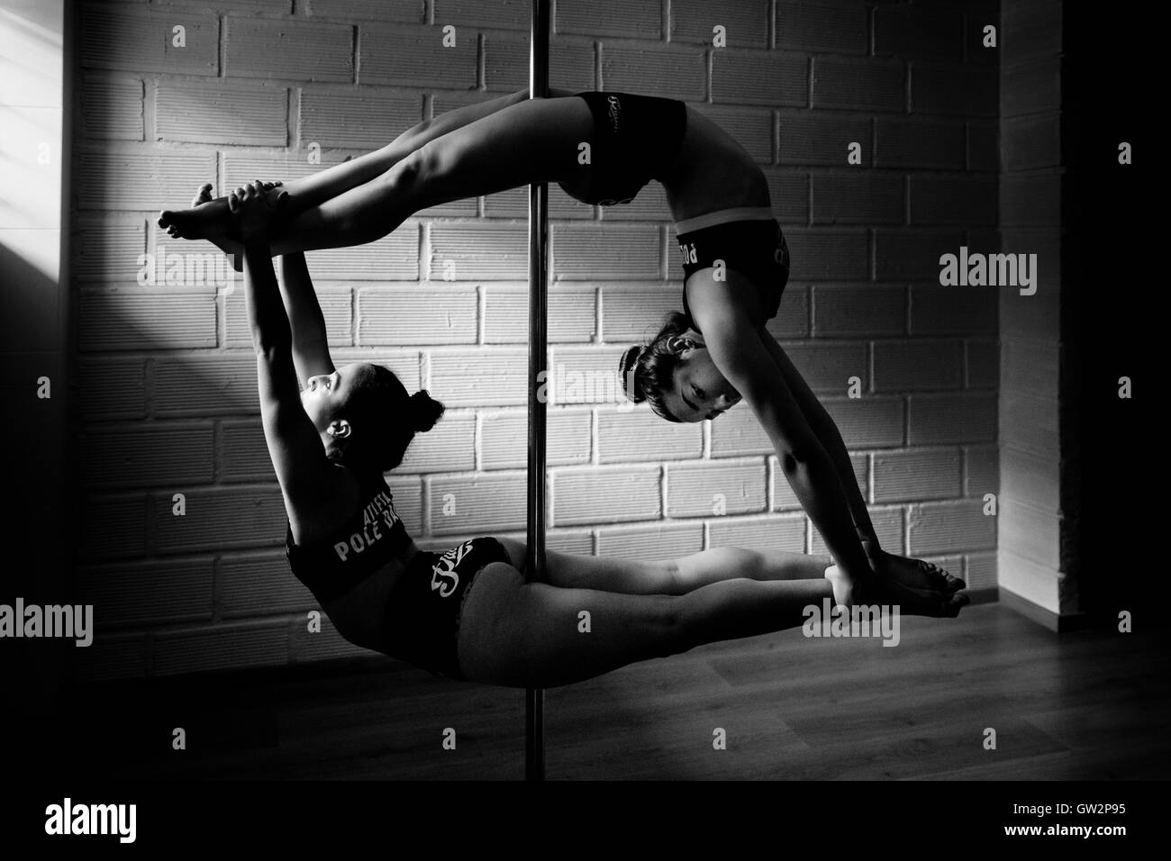 Valeria Aboultaif et Carolina Echavarria, les jeunes danseurs pôle colombien, tourner autour d'un poteau pendant une session de formation dans le milieu universitaire Pin Up à Medellín, Colombie. Banque D'Images