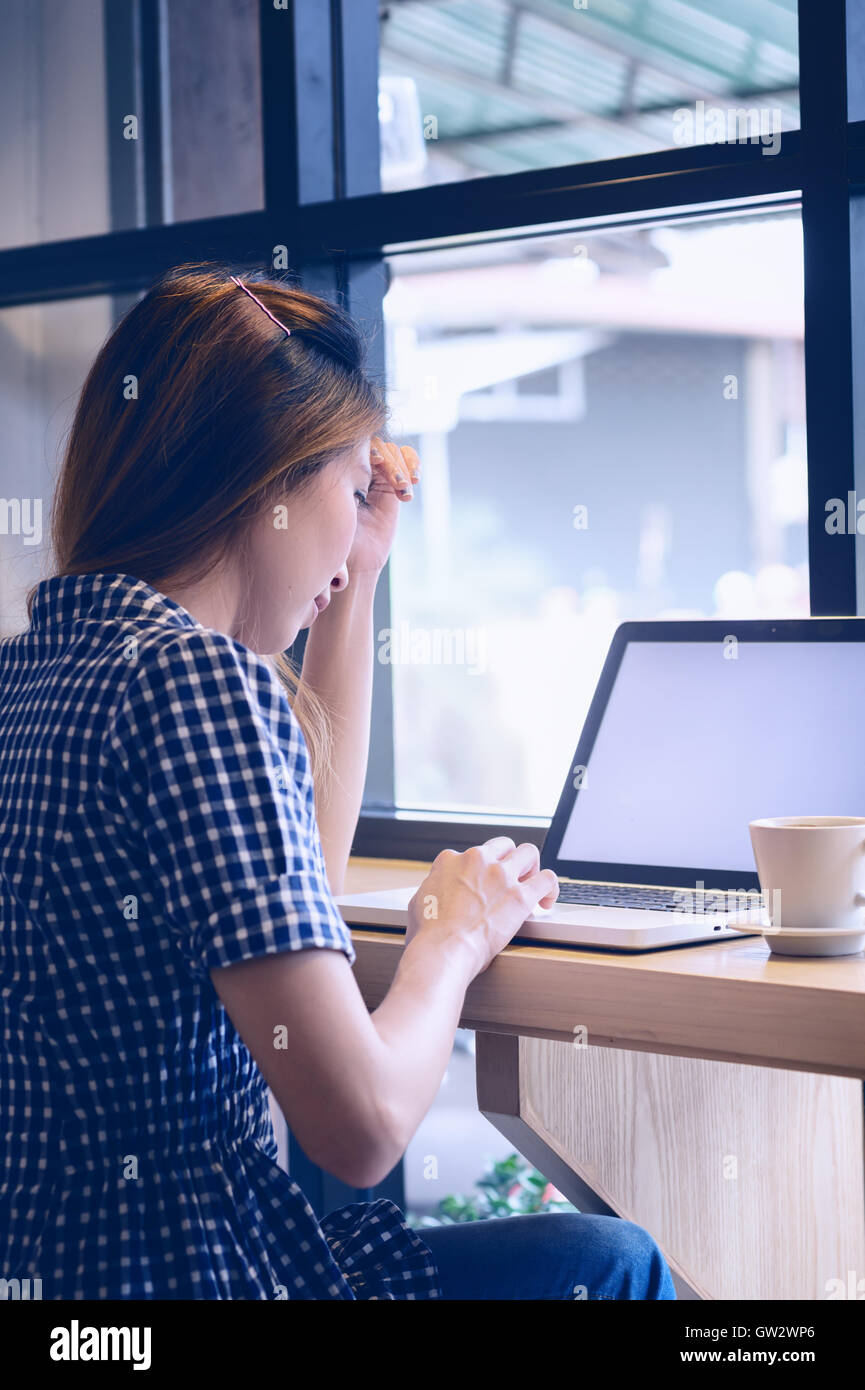 Belle Asie en utilisant son ordinateur portable et de boire tasse de café en café, de vacances concept. Banque D'Images