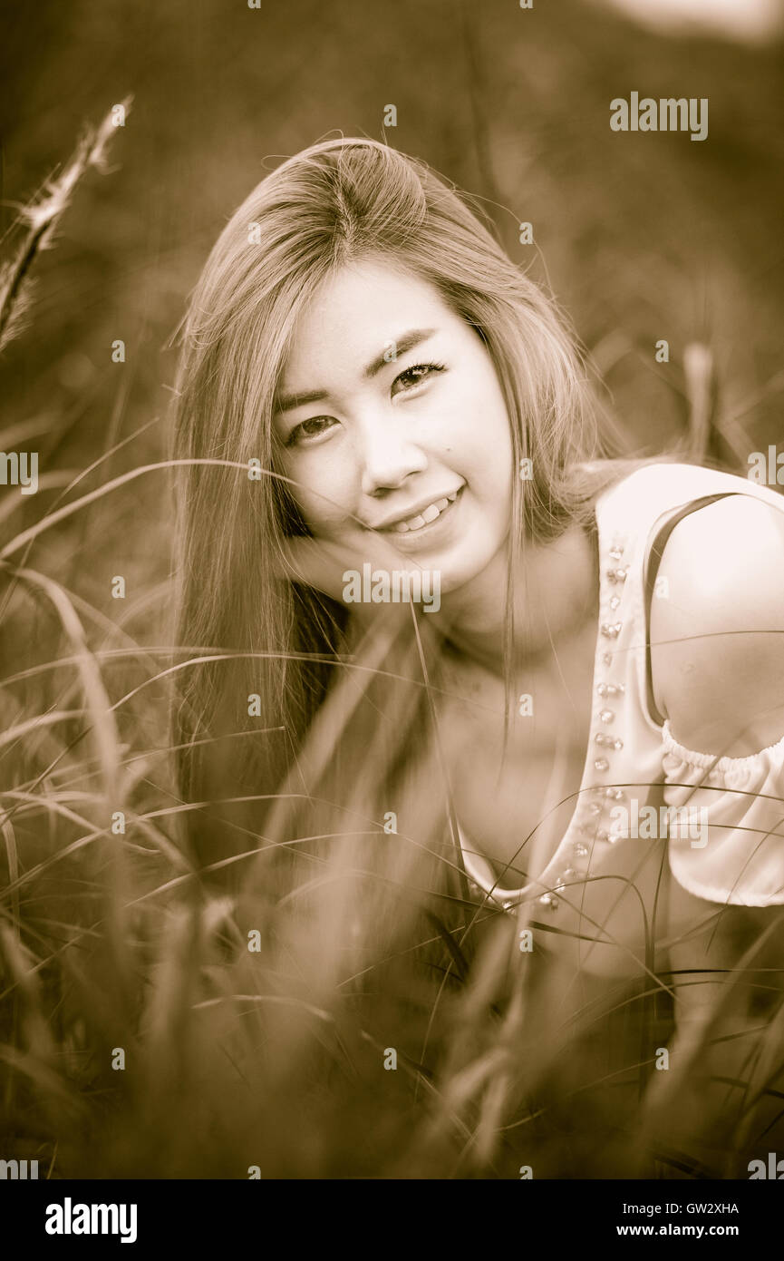 Portrait Thai belle fille s'asseoir sur l'herbe Banque D'Images