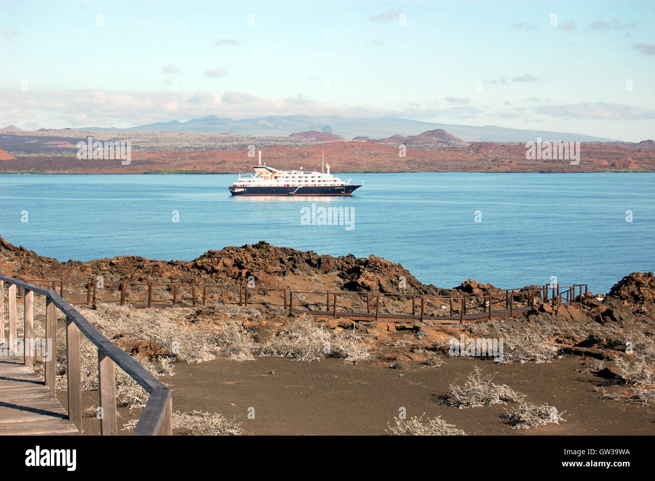 Côte volcanique aride de Sullivan Bay avec bateau de croisière dans la distance. Bartolomeo, l'île de Galapagos. Banque D'Images