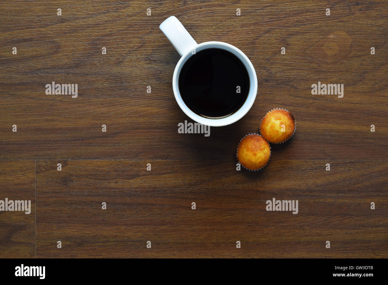 Vue de dessus de tasse de café et muffins sur une table en bois. Pause au travail, style de concept. Banque D'Images