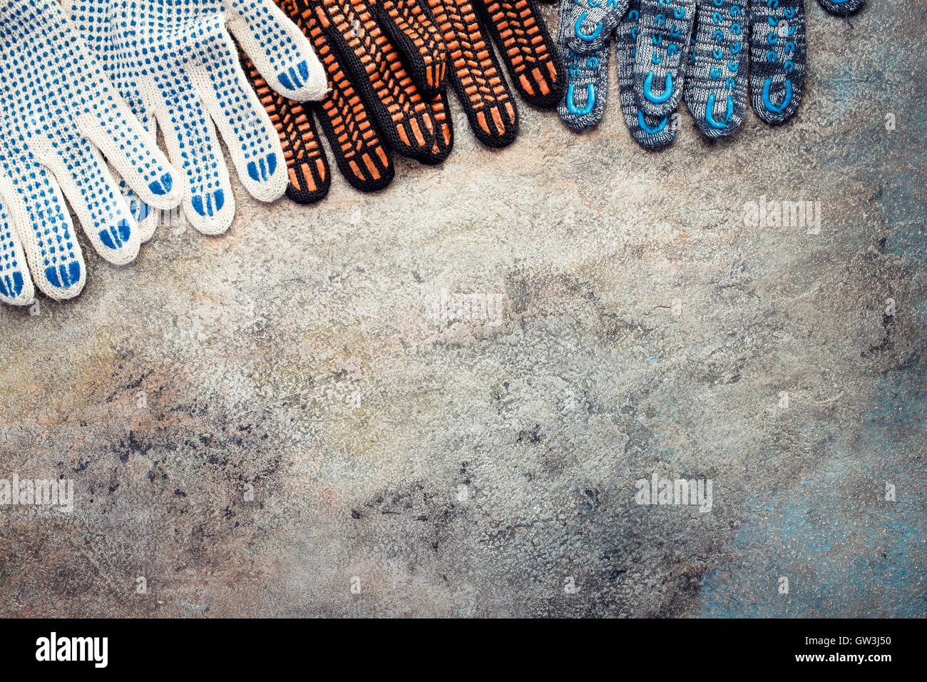 Gants de travail textile multicolore sur fond vieux Banque D'Images