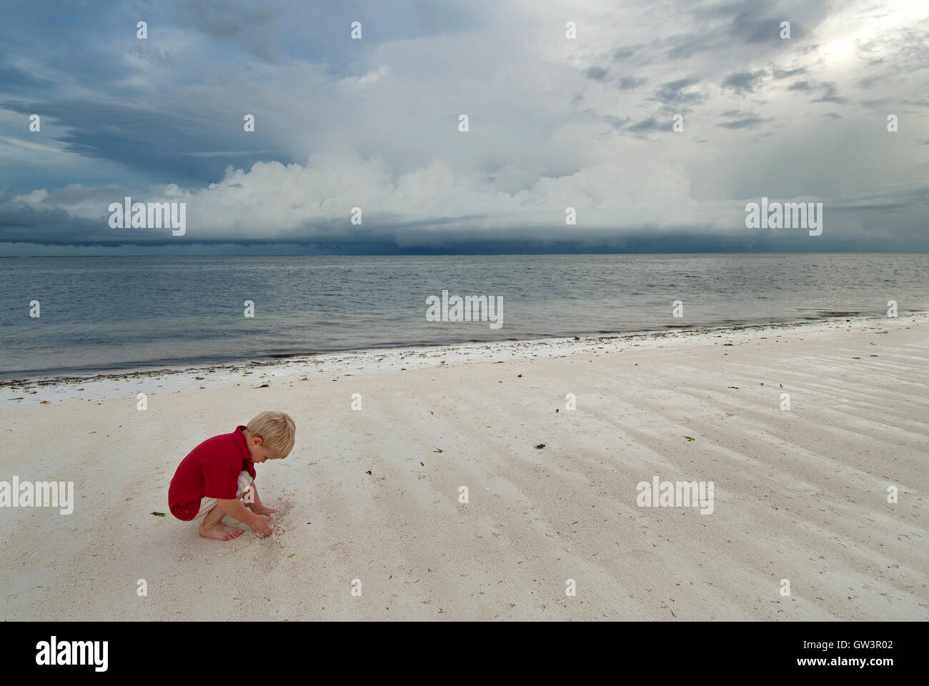 Jeune garçon jouant sur la plage. Banque D'Images