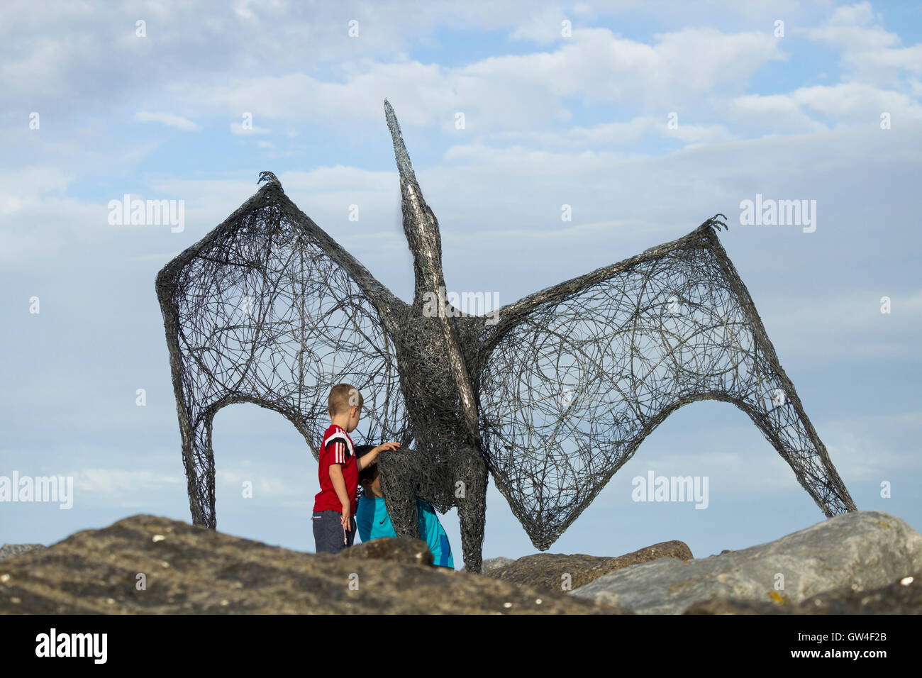 Staithes, North Yorkshire, UK, 10 septembre 2016. Météo : les enfants à la sculpture au ptérodactyle par Emma Stothard sur le mur du port à Staithes Art Festival. Pendant le week-end une centaine de chalets dans le pittoresque village de pêcheurs Yorkshire temporaire deviennent les galeries d'artistes exposent et vendent des peintures, estampes, sculptures, bijoux... à Staithes Festival des arts et du patrimoine. Staithes a longtemps été un aimant pour les artistes. Credit : Alan Dawson News/Alamy Live News Banque D'Images