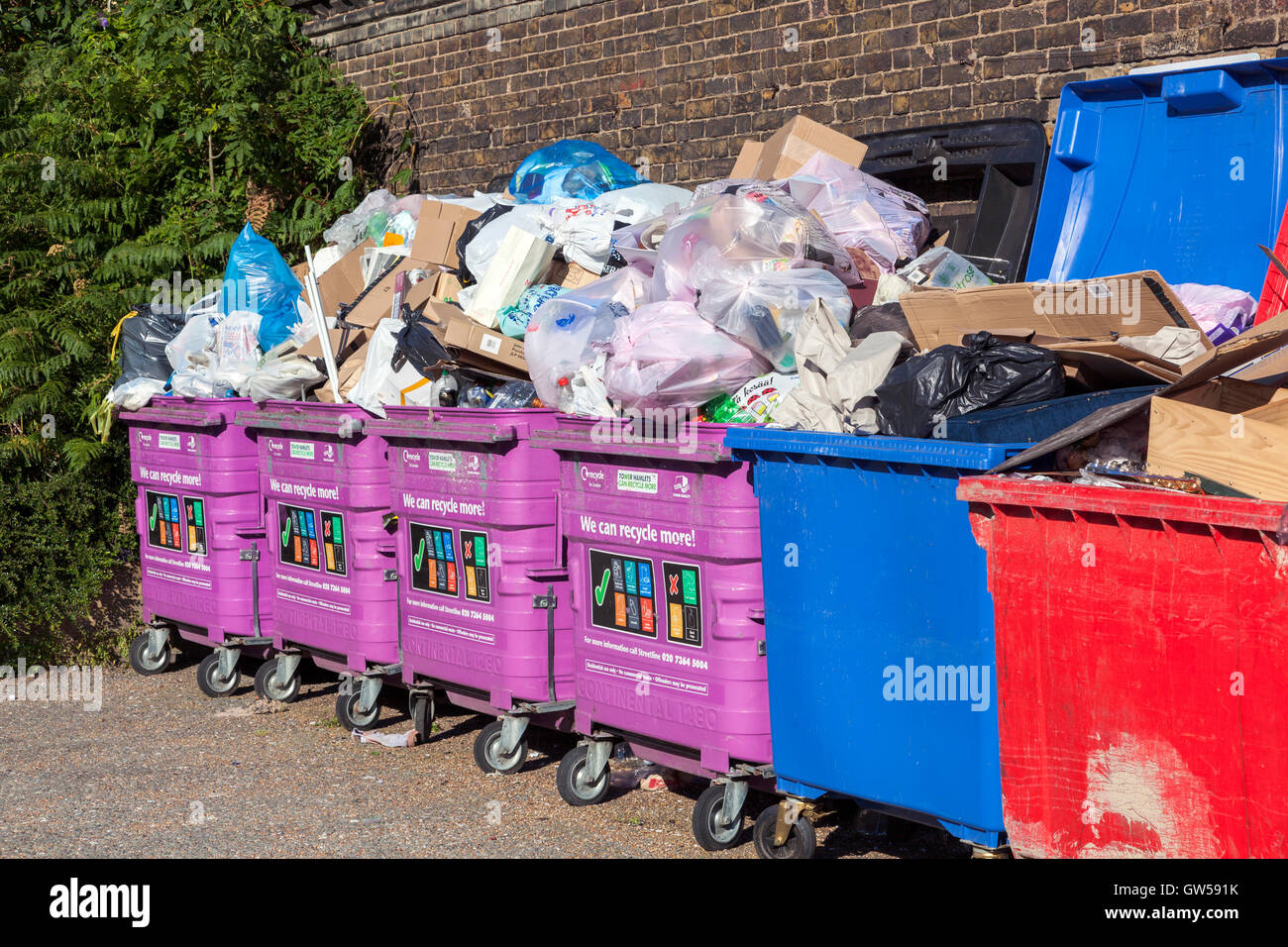 Bacs de recyclage mixte débordante dans Limehouse, Tower Hamlets, London Banque D'Images