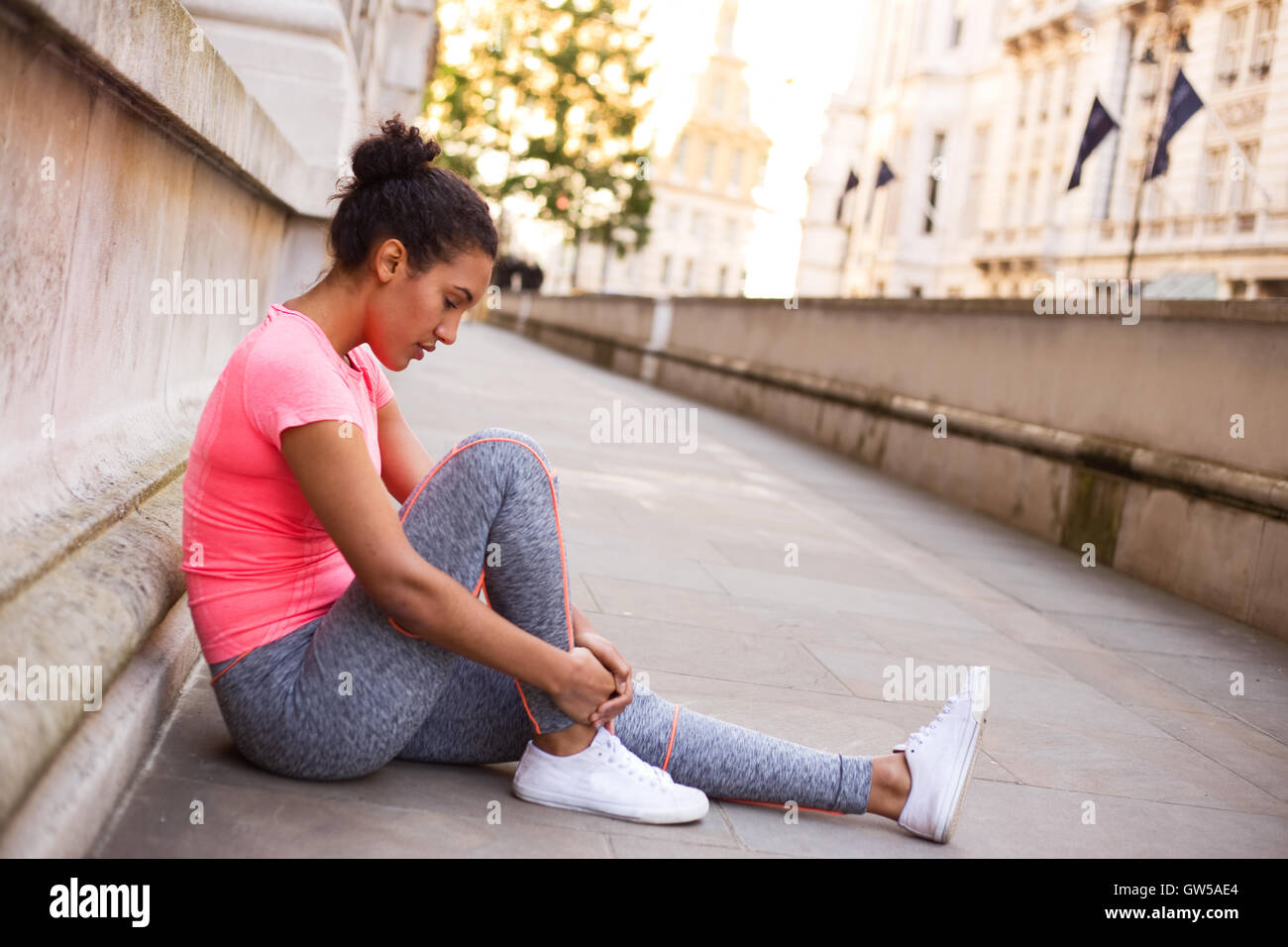 Jeune femme sentant son cheville douloureuse après l'exercice Banque D'Images