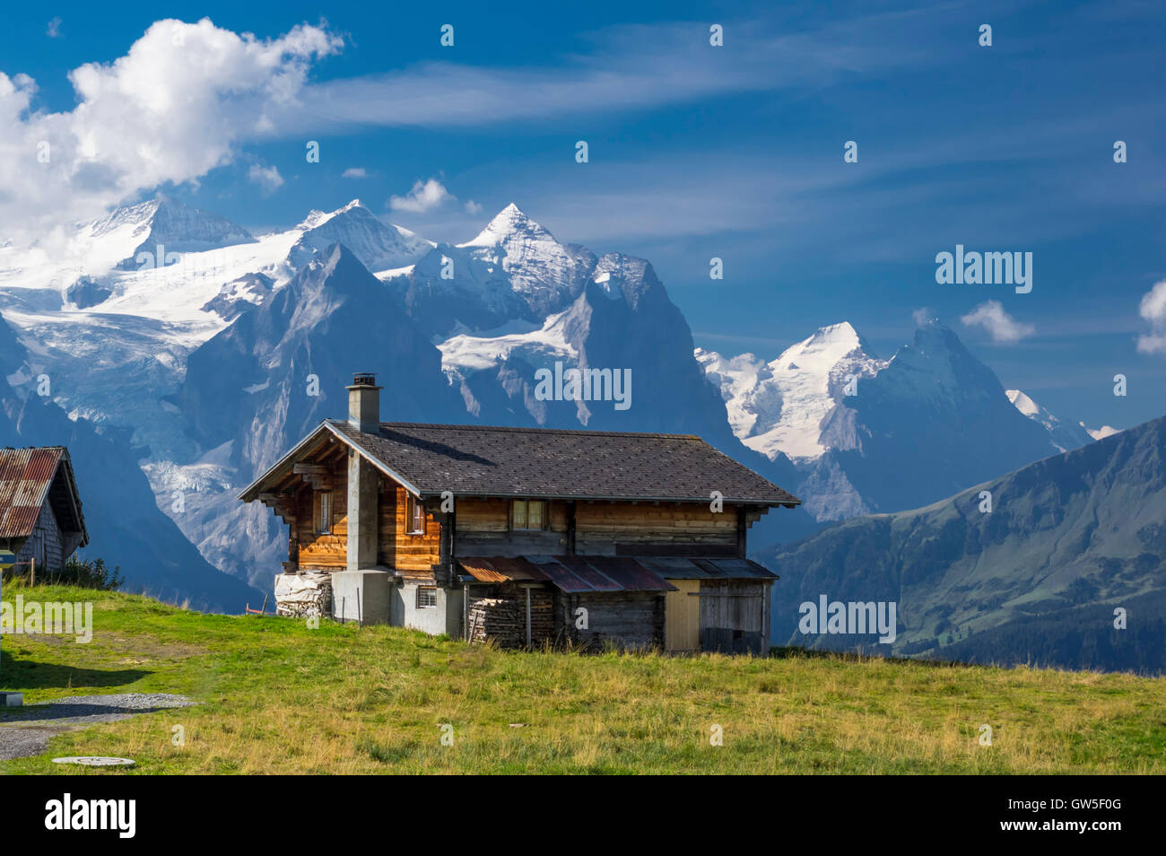 Chalet dans les Alpes Suisses en face de montagnes couvertes de neige. Banque D'Images