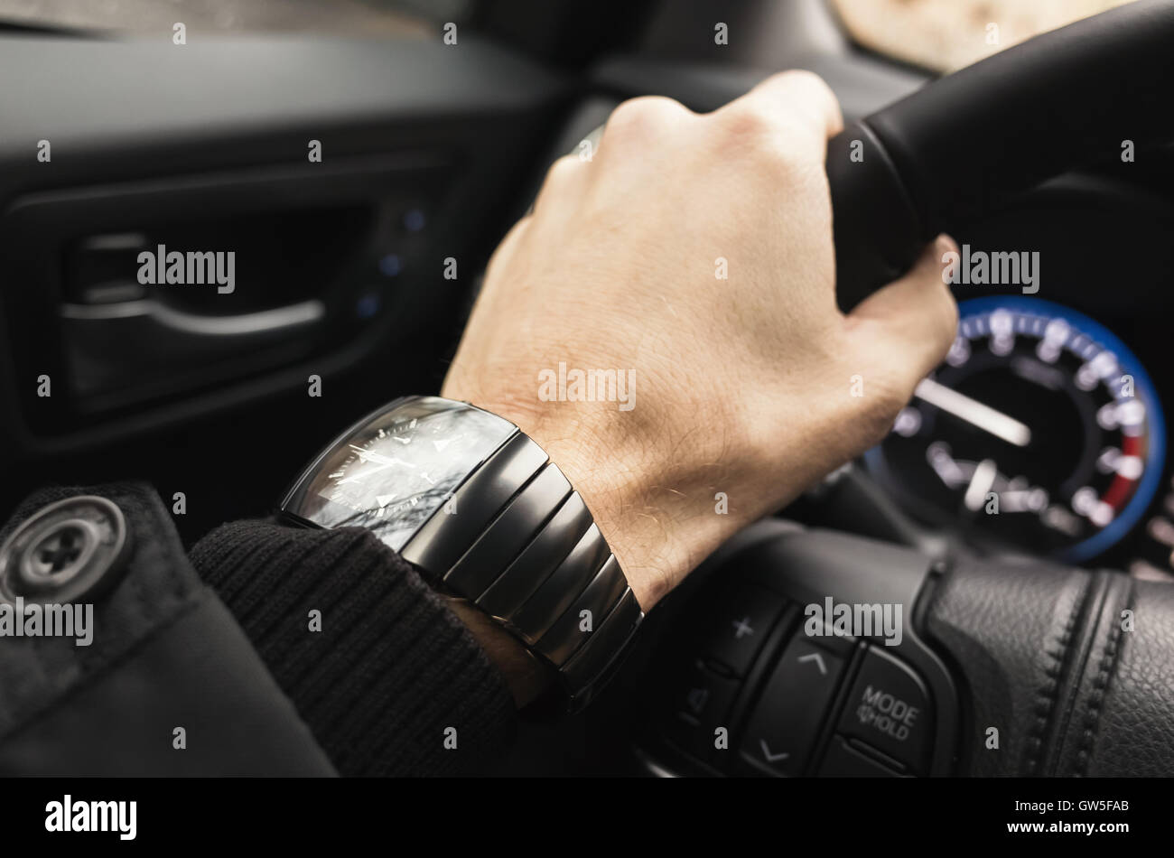 Montre-bracelet avec la main du pilote sur un volant de voiture de luxe. Photo Gros Plan avec selective focus Banque D'Images