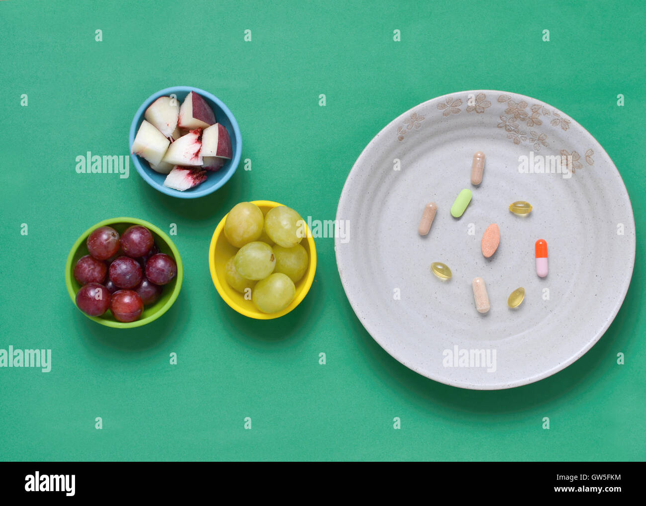 Les compléments alimentaires, et les fruits dans des bols colorés, sur nappe salue Banque D'Images