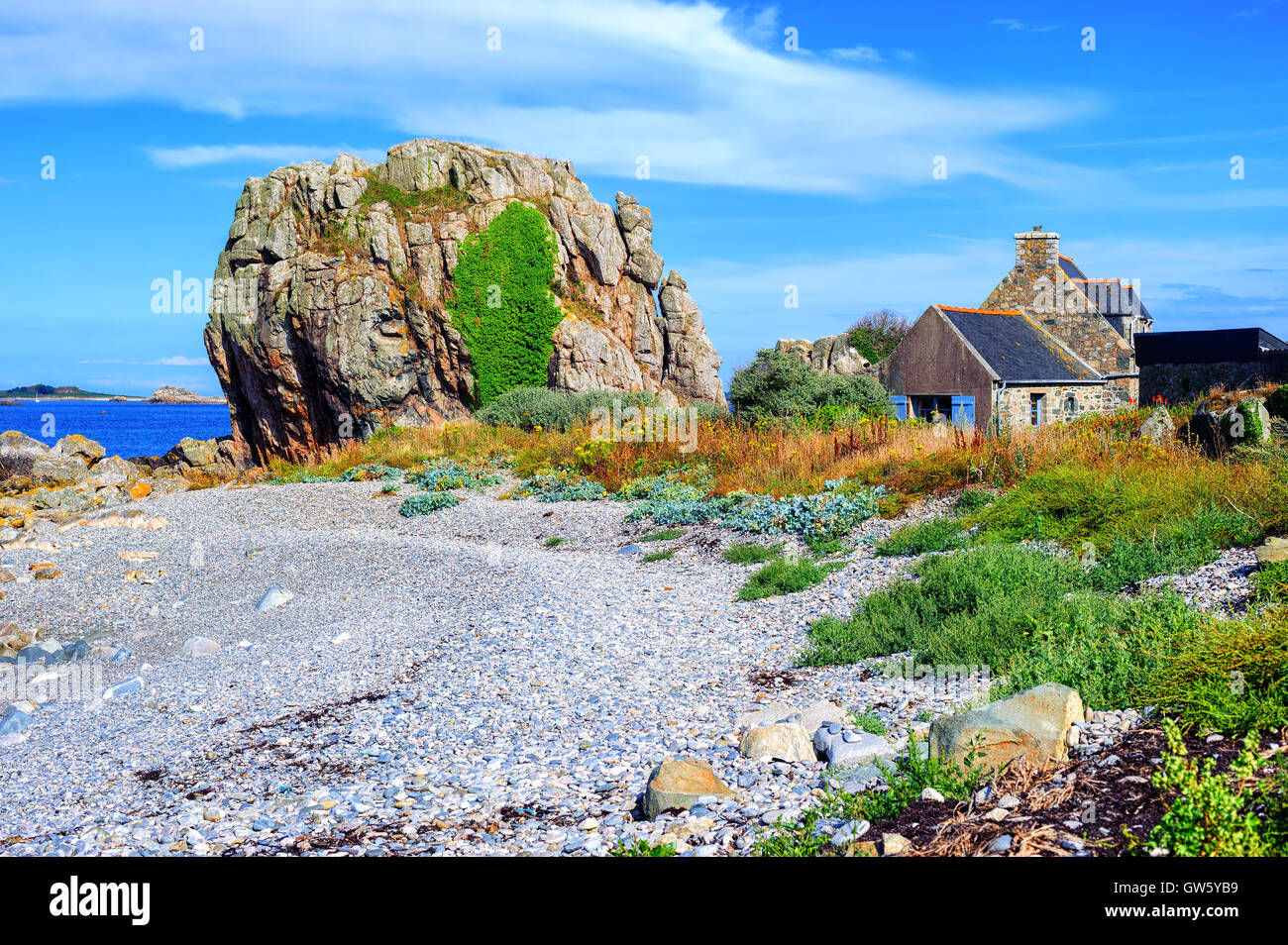 Maison bretonne en pierre et un rocher sur la plage de l'Atlantique ...