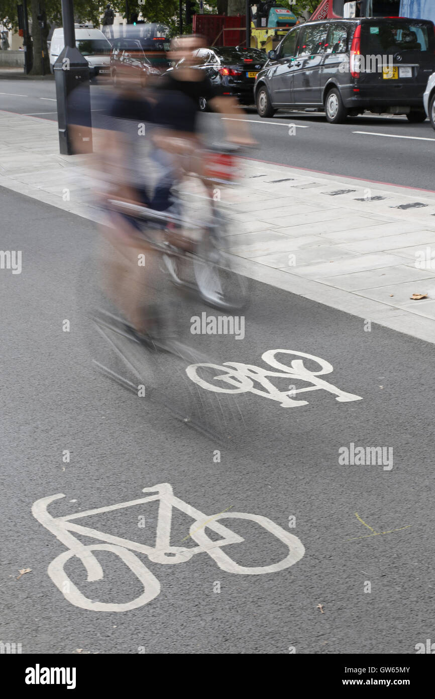 Deux cyclistes (floue en raison de la vitesse) sur London's new cycle autoroute est-ouest de Victoria Embankment à Westminster Banque D'Images