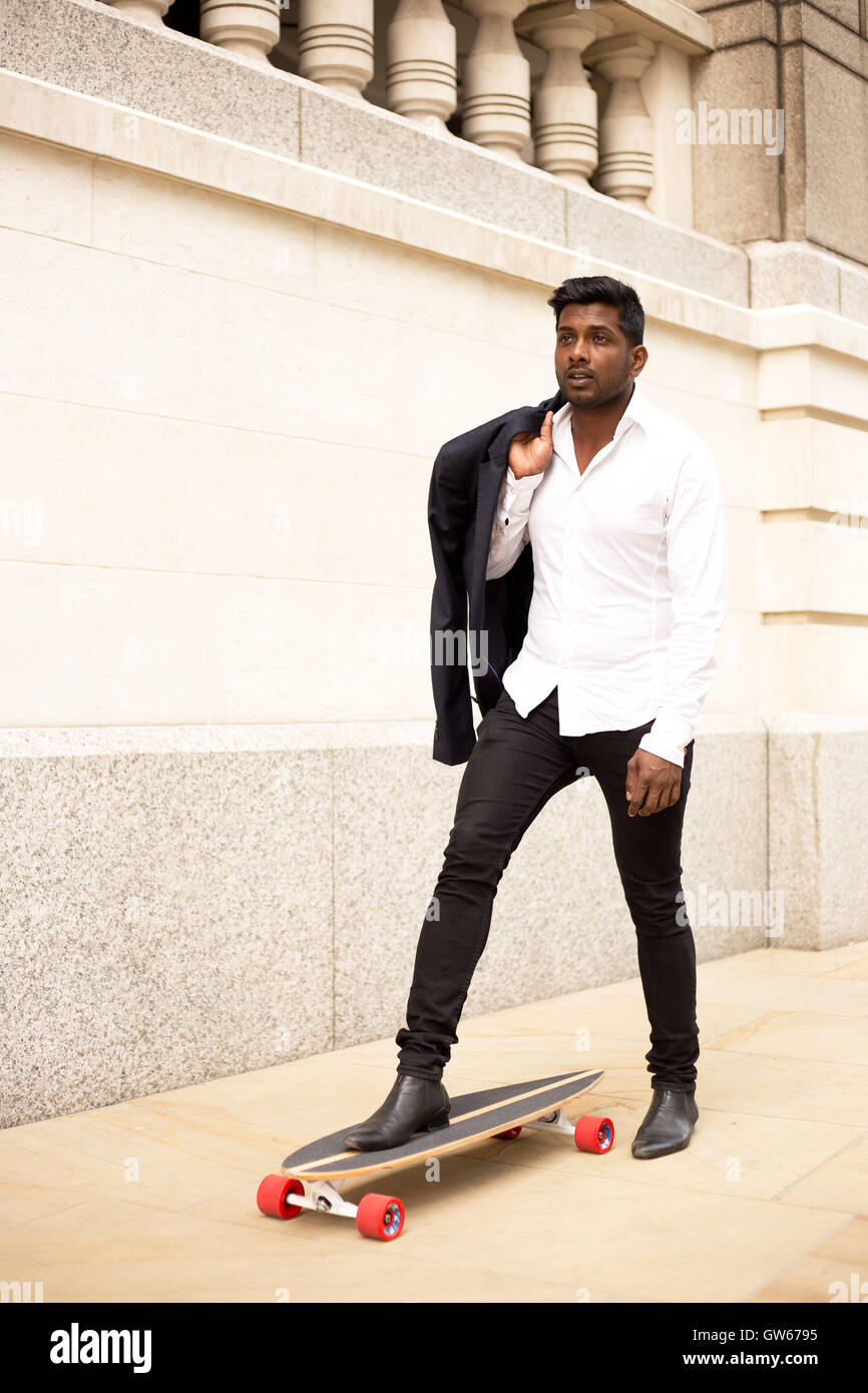 L'homme d'affaires avec son skateboard Banque D'Images
