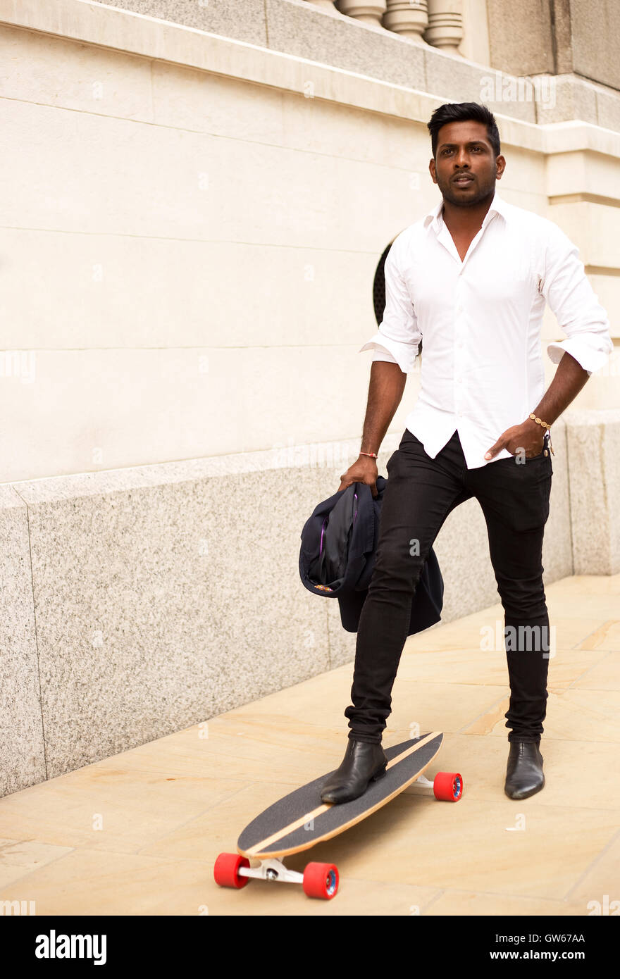 L'homme indien avec son skateboard Banque D'Images