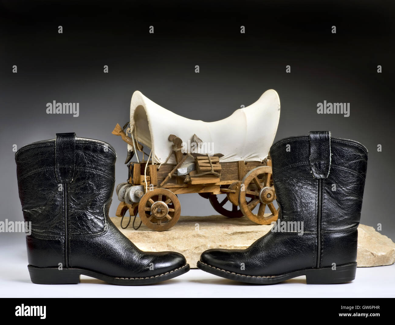 Kids cowboy bottes noires et chuck wagon avec prix pour votre type. Banque D'Images