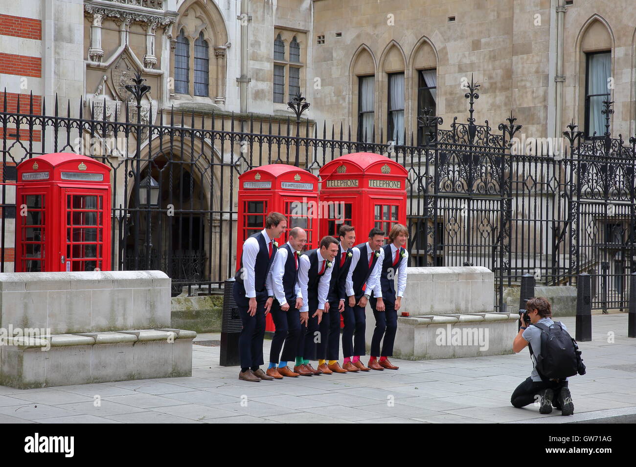 Six hommes posant devant une cérémonie de mariage sur Carey Street en face de la façade extérieure de Royal Courts of Justice, London, UK Banque D'Images