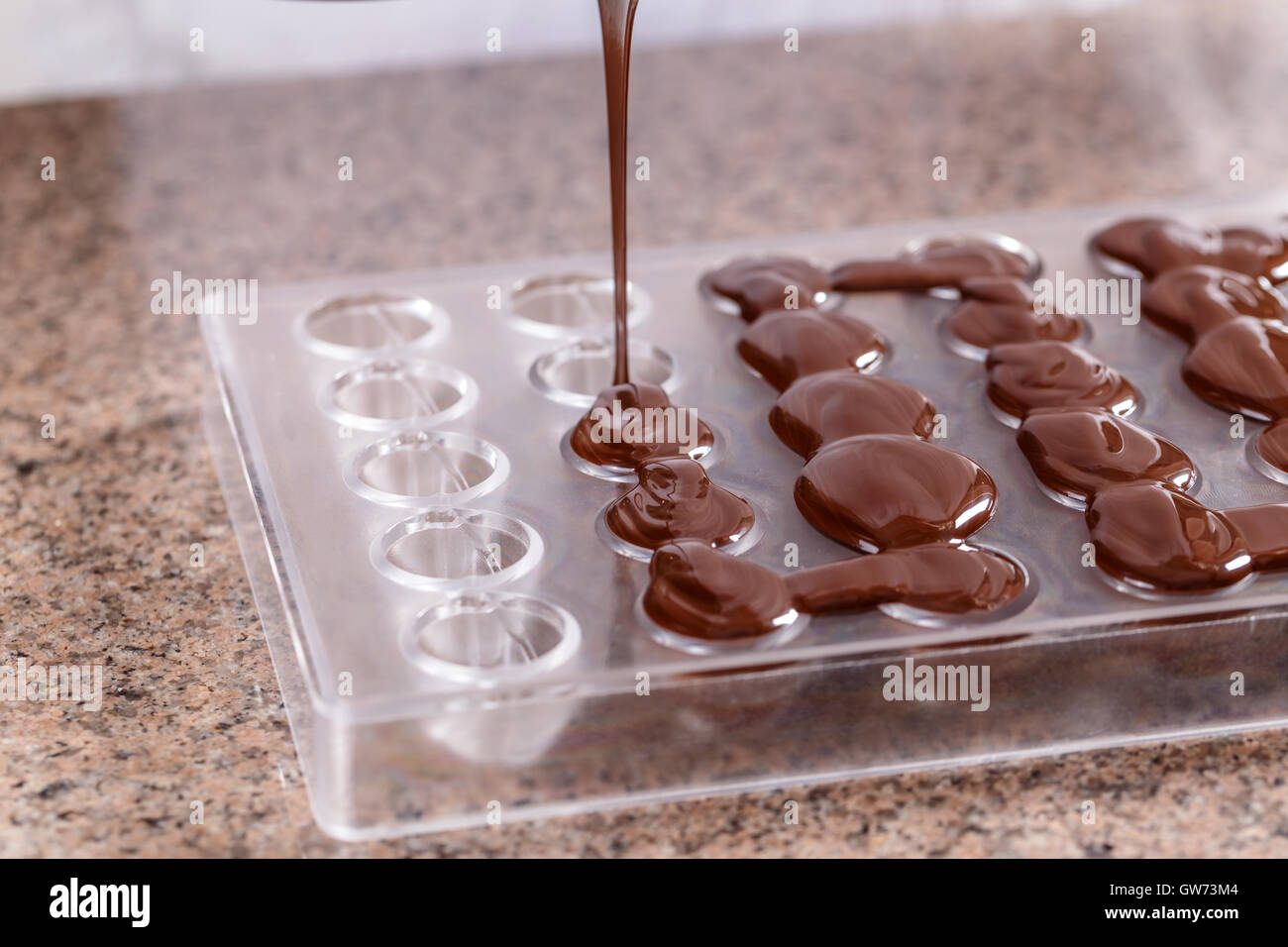 Verser le liquide dans la forme de chocolat Banque D'Images