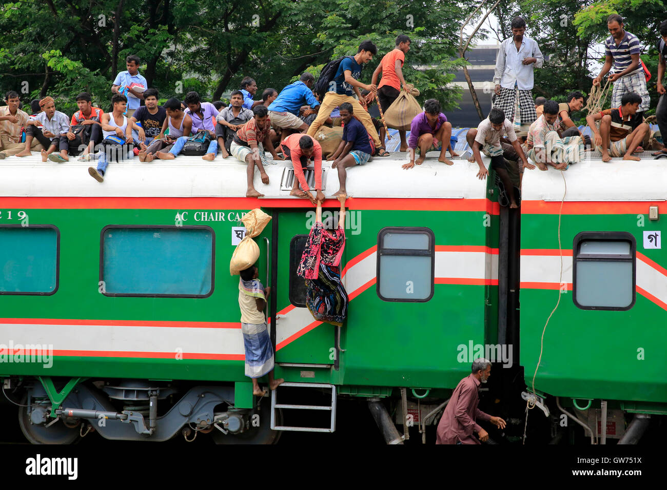 Dhaka, Bangladesh. 12 Septembre 2016 : une femme monter sur le toit d'un train à la gare de l'aéroport pour rejoindre son village pour les vacances de l'aïd. Banque D'Images