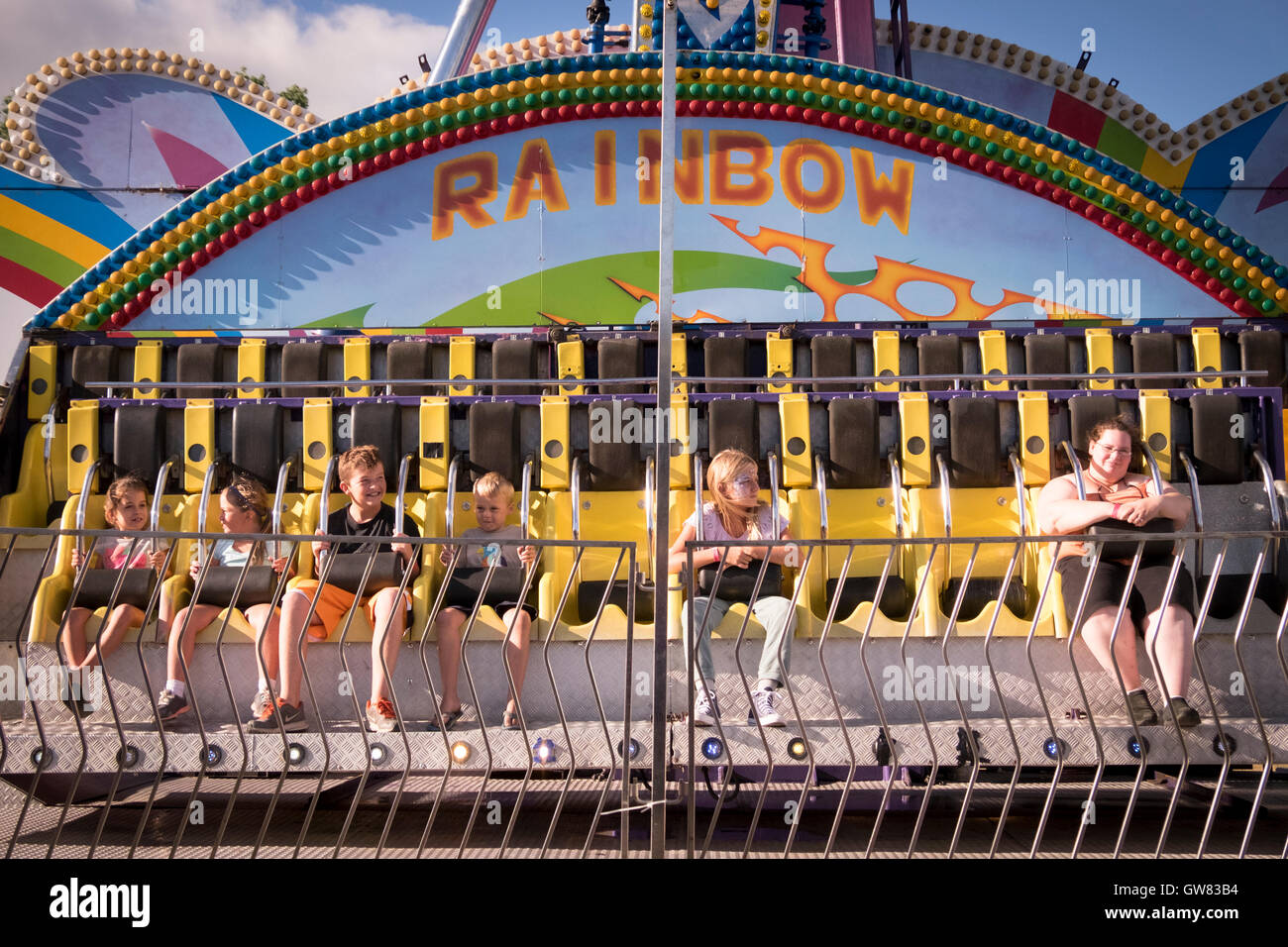 Six enfants attendent le début d'une ride sideshow à un country fair Banque D'Images
