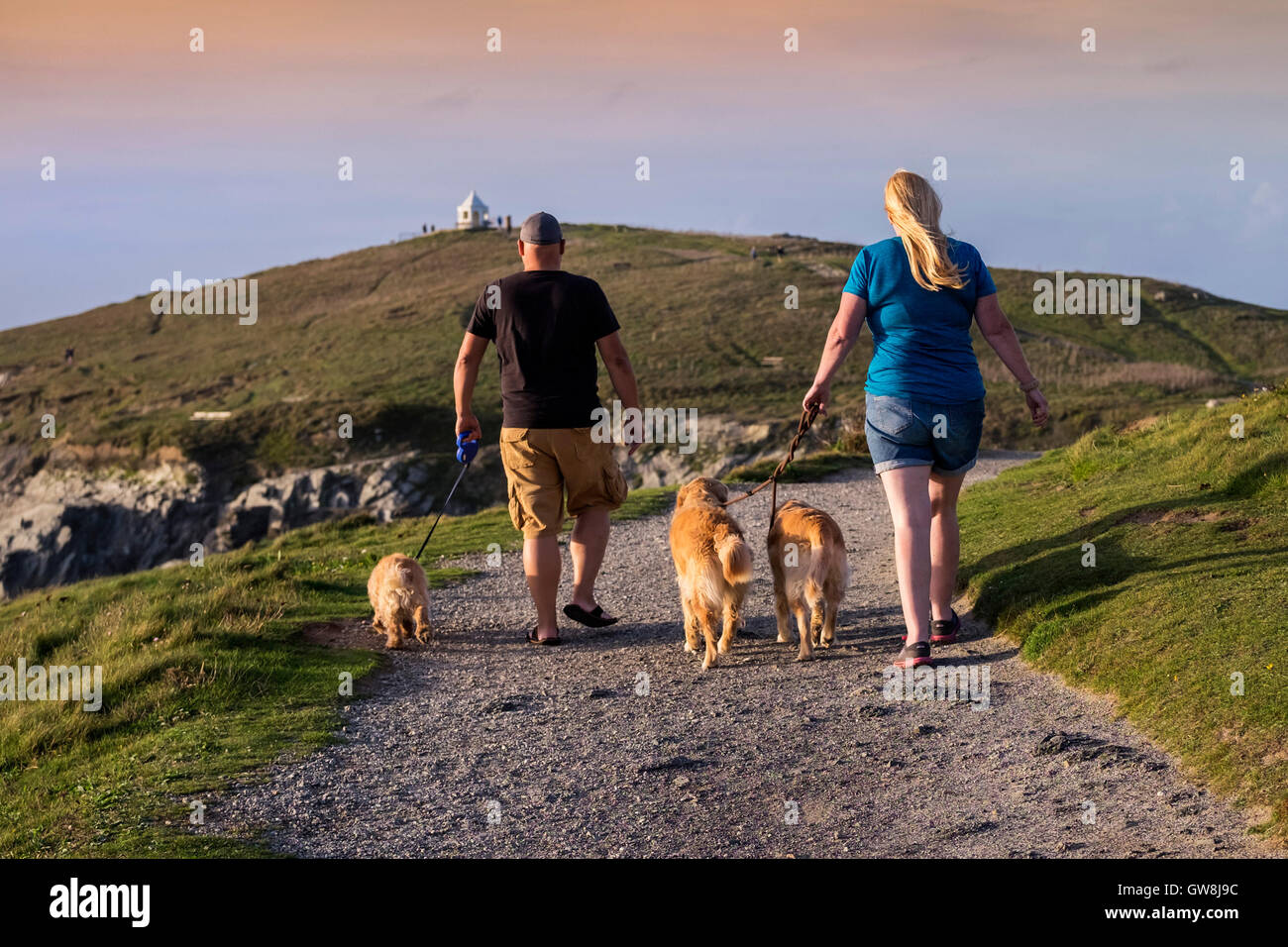 Les promeneurs de chiens sur la tête de Towan à Newquay, Cornwall, Angleterre. Banque D'Images