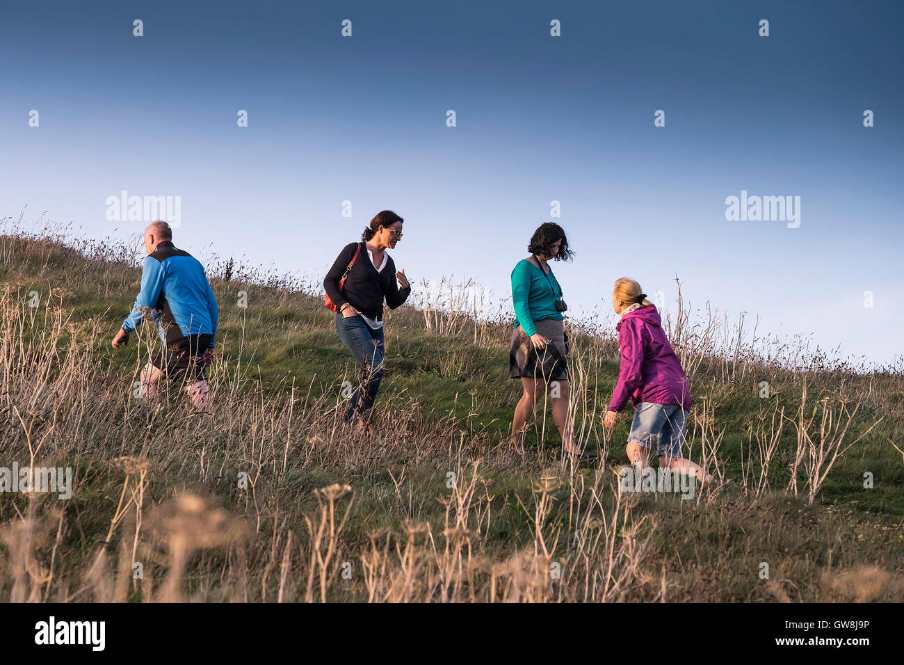 Les gens à monter et descendre une colline sur la tête de Towan à Newquay, Cornwell. Banque D'Images